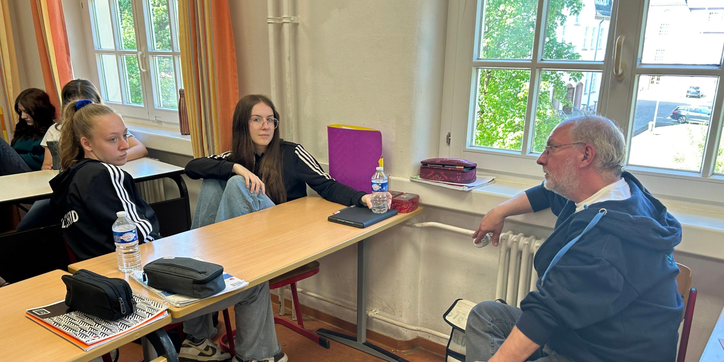 Jolie (links) und Lanah (Mitte) besprechen mit Referent Michael Federkeil von der Fachstelle Jugend die Details für den geplanten Kuchenverkauf.
