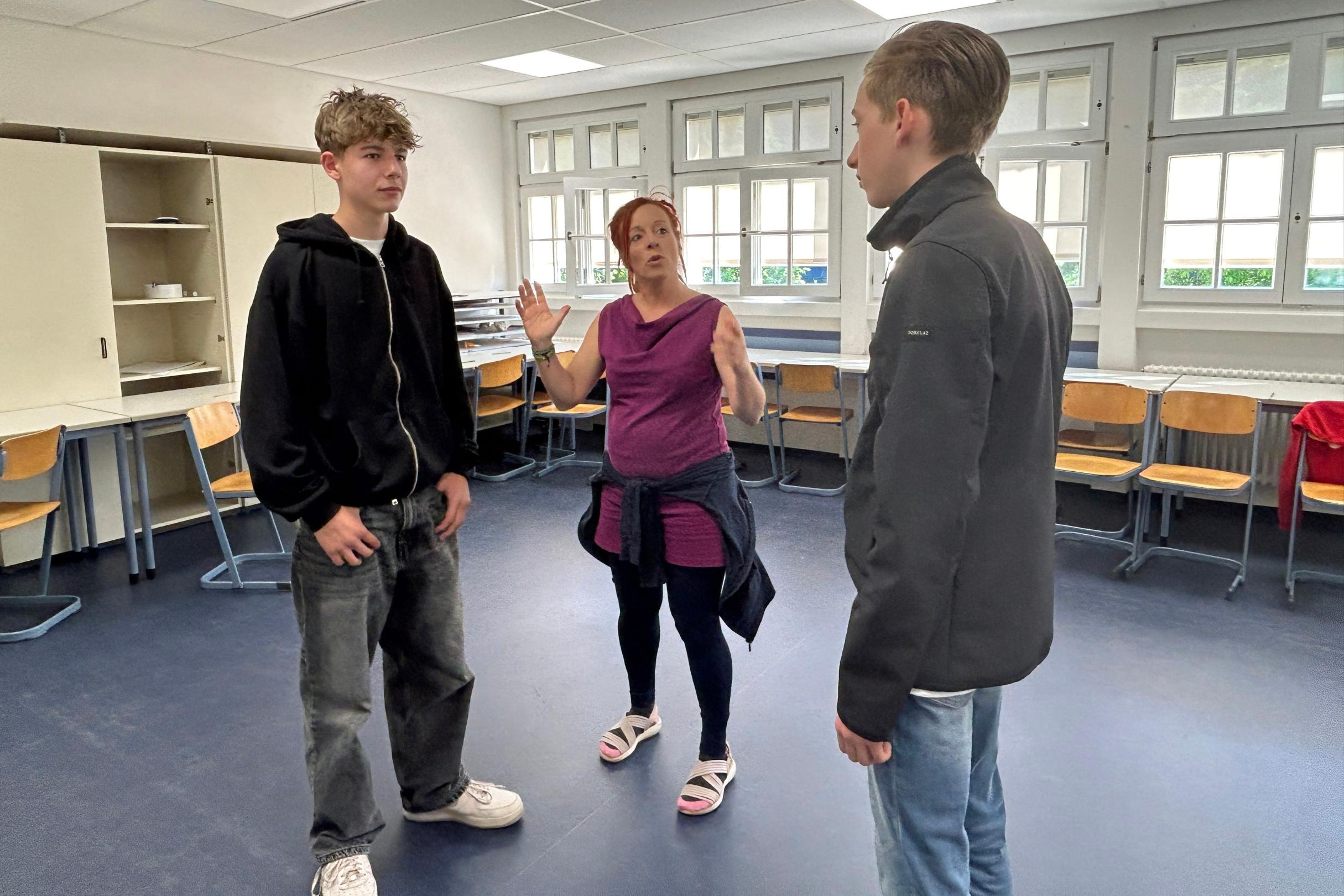 Theaterpädagogin Sonni Maier macht mit Tim und Tim im Workshop eine Übung zur Stärkung des Selbstbewusstseins.