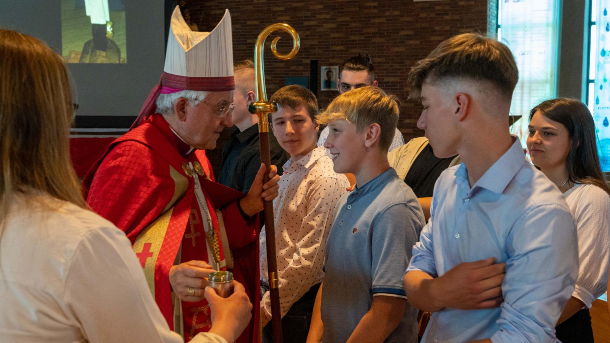 Weihbischof Gebert spendet Jugendlichen in der Jugendkirche MIA das Sakrament der Firmung.