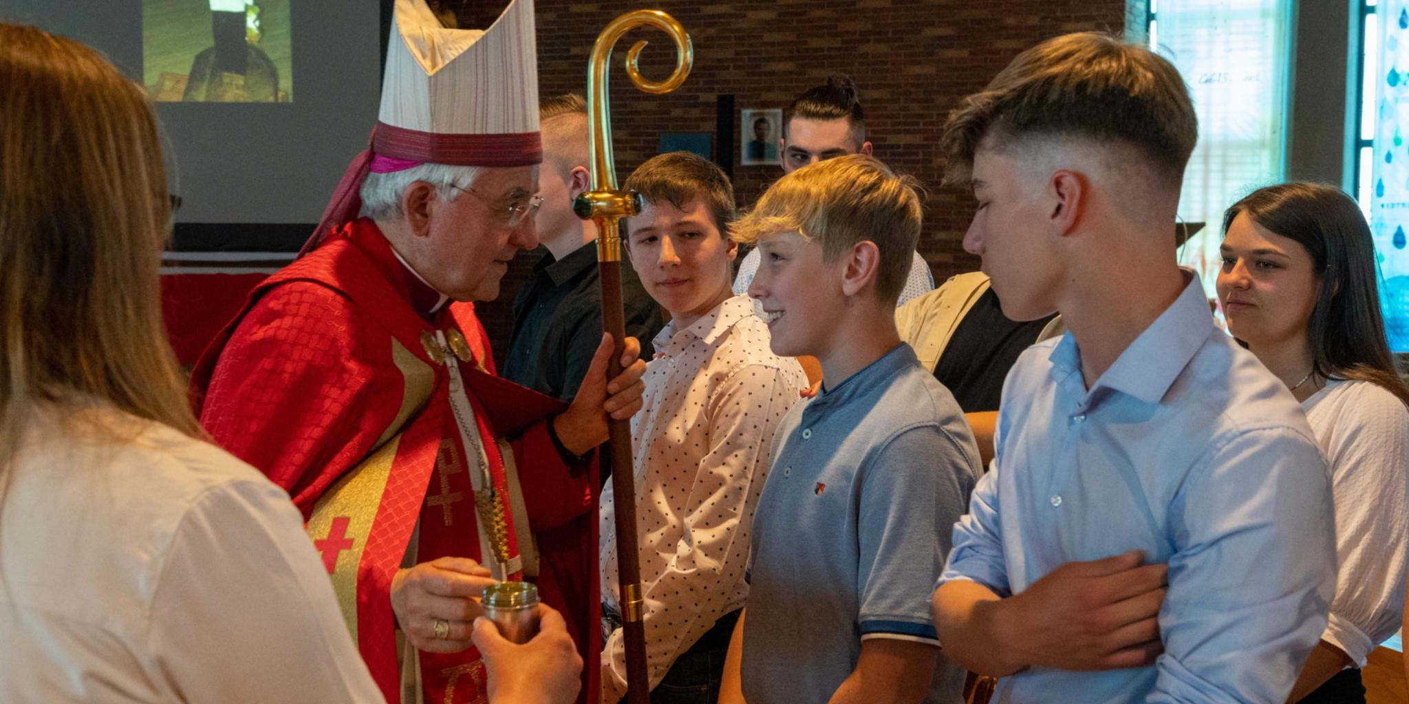 Weihbischof Gebert spendet Jugendlichen in der Jugendkirche MIA das Sakrament der Firmung.