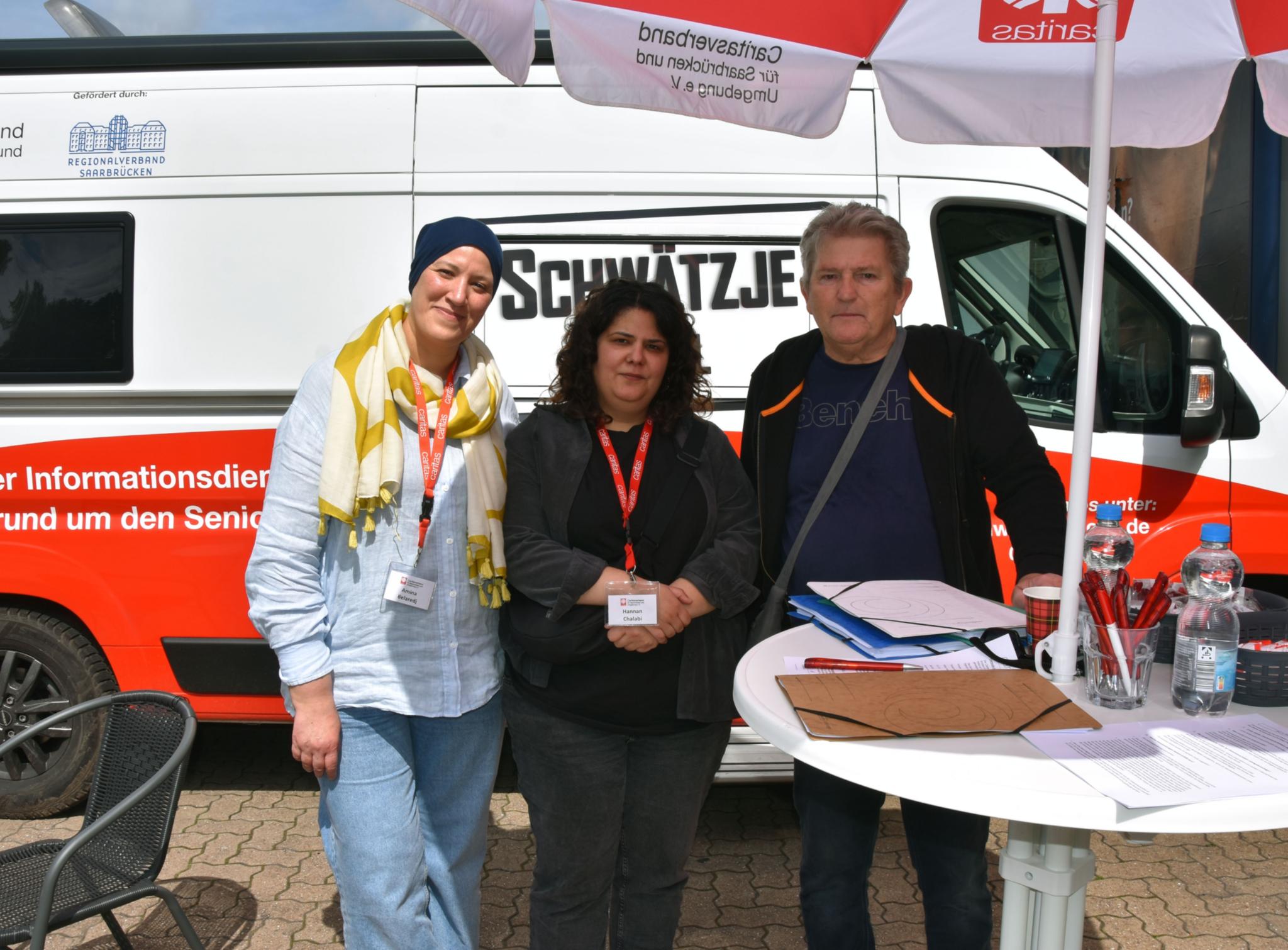 Die Caritasmitarbeiterinnen Amina Belardj, Hannan Chalabi unterstützen Herbert Wilhelm aus Lauterbach mit Antragsformularen.