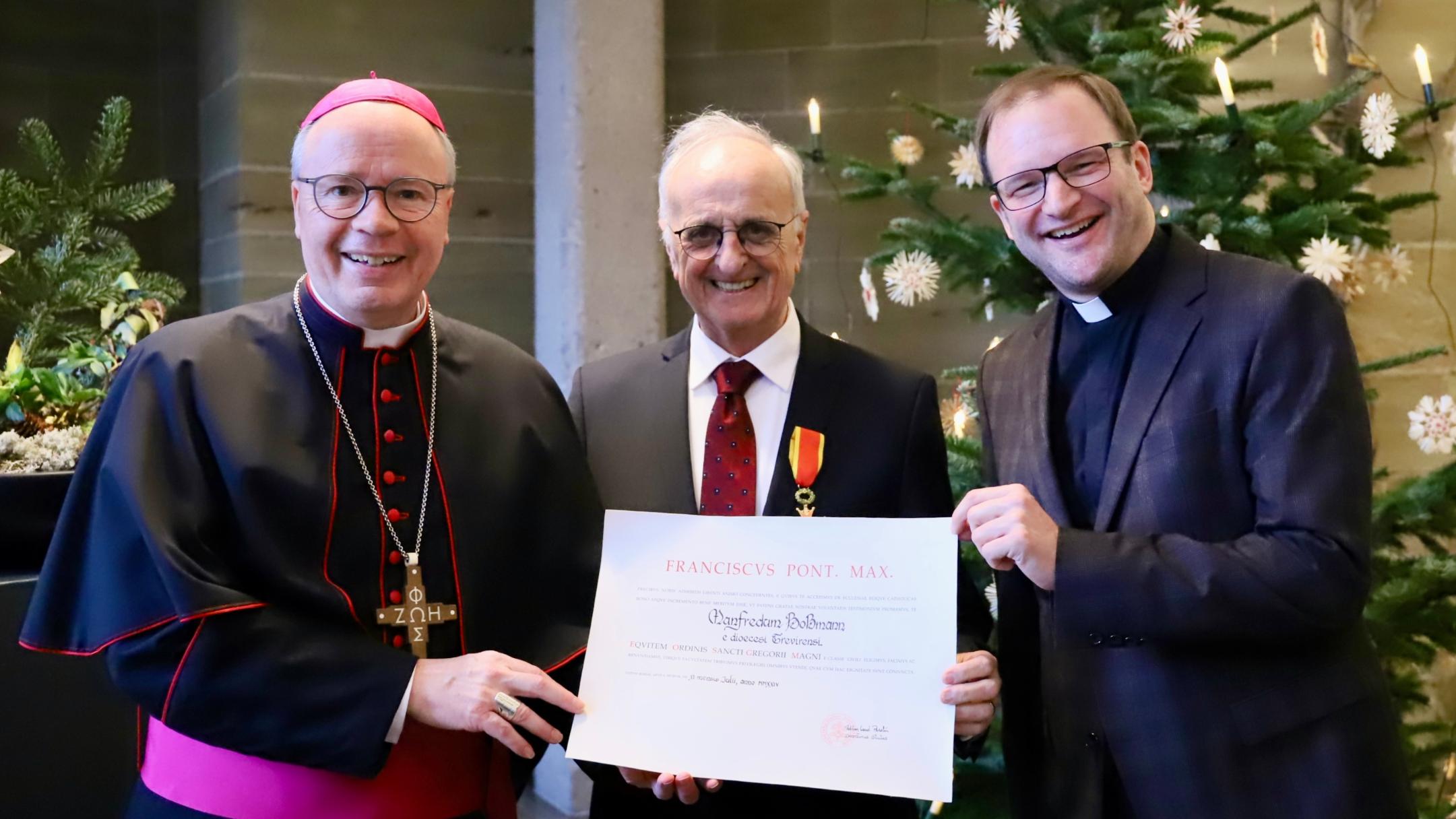 Gregoriusordensträger Manfred Boßmann (Mitte) mit Bischof Ackermann (li.) und Dekan Frank Kleinjohann