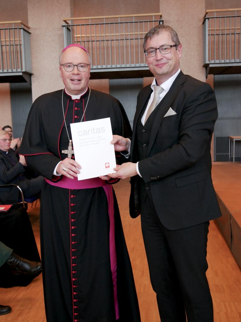 Bischof Ackermann übergibt dem neuen Diözesan-Caritasdirektor die Ernennungsurkunde.