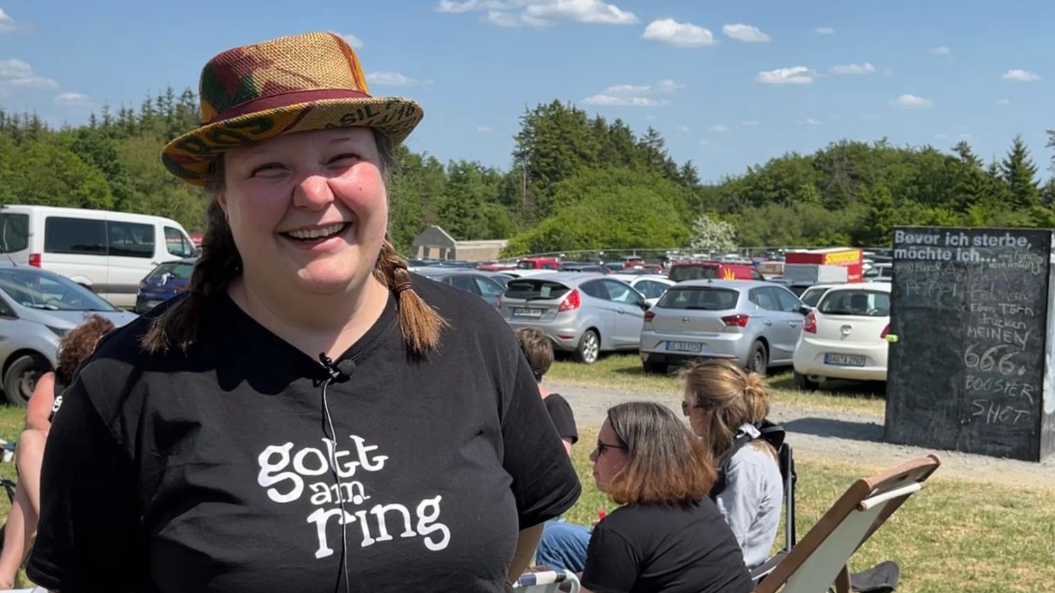 Eine Frau mit Hut und TShirt mit der Aufschrift 'Gott am Ring'