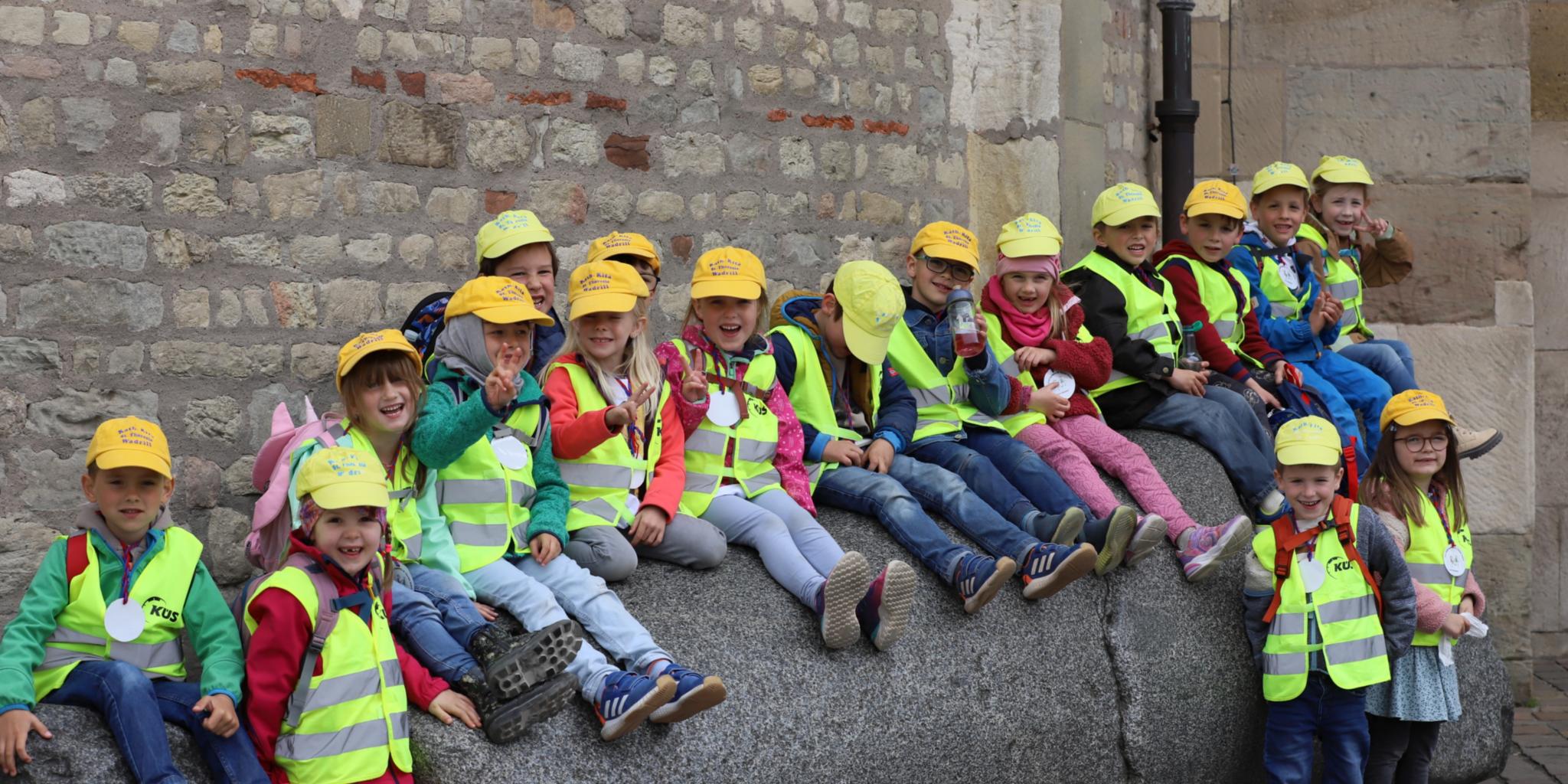 Kinder der Kita St. Theresia in Wadrill sitzen auf dem Domstein