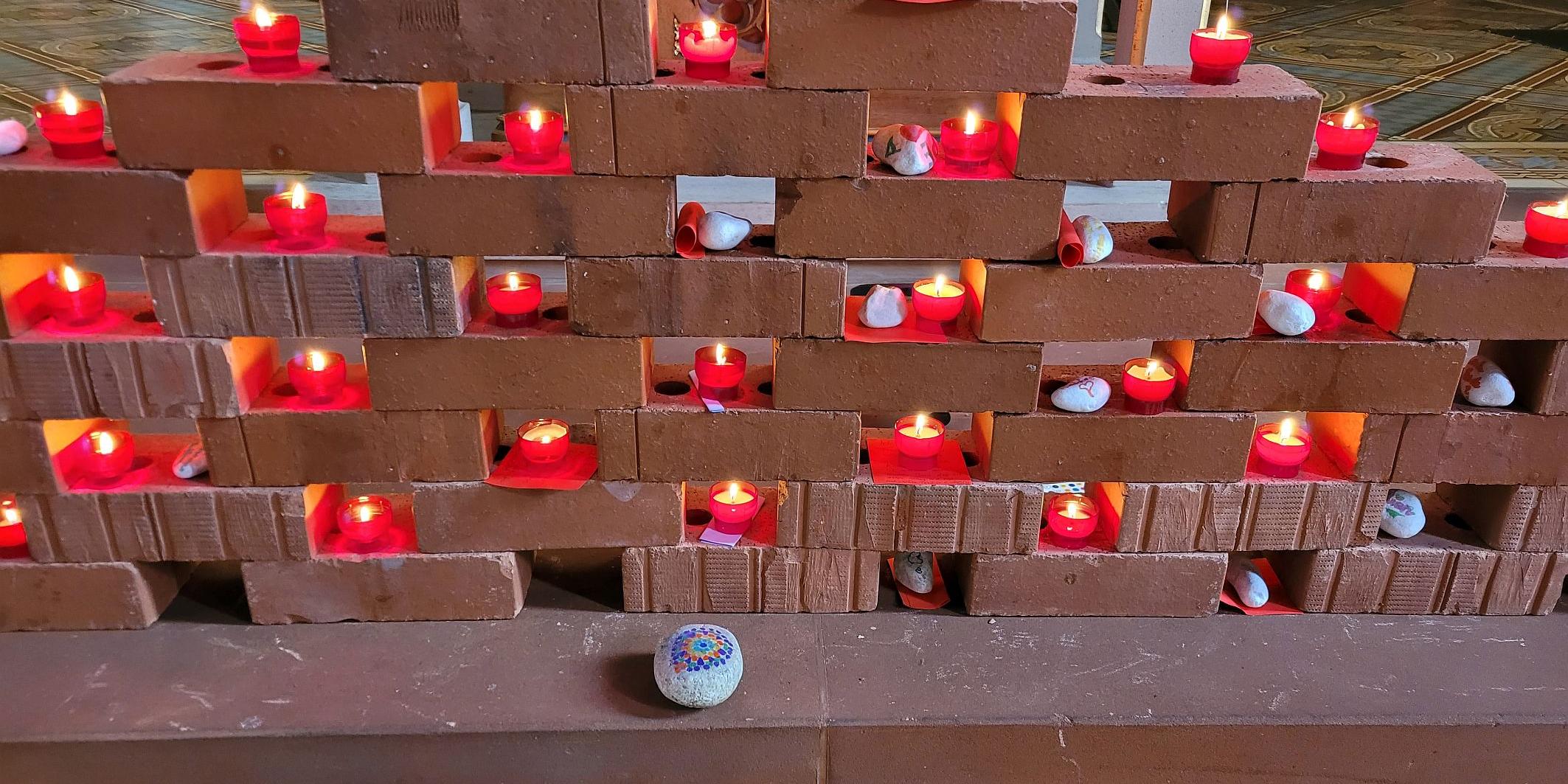 Die „Klagemauer“ aus Ziegelsteinen  mit Kerzen und Zetteln.
