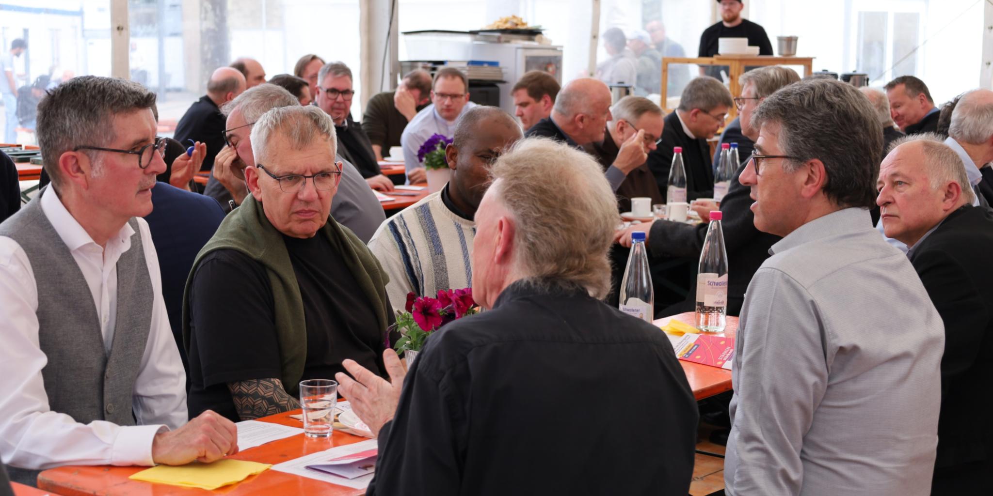 Priester im Austausch im Begegnungszelt