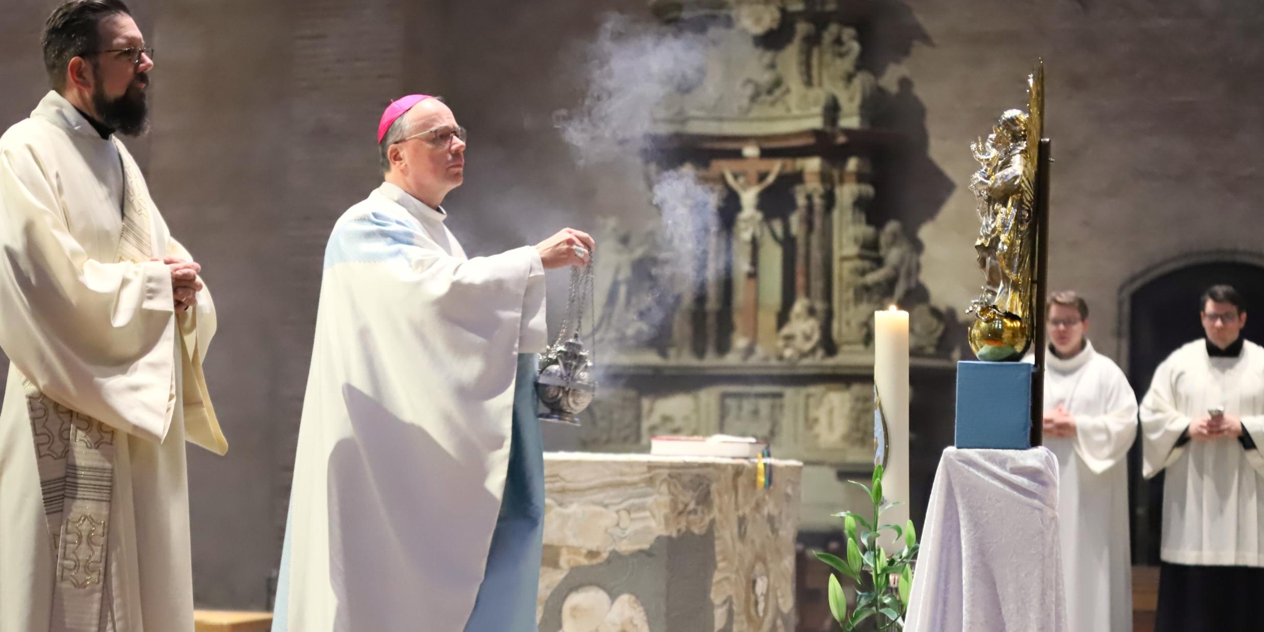 Bischof Ackermann vor der Marienstatue, die am Hochfest Maria Immaculata im Altarraum ihren Platz hat