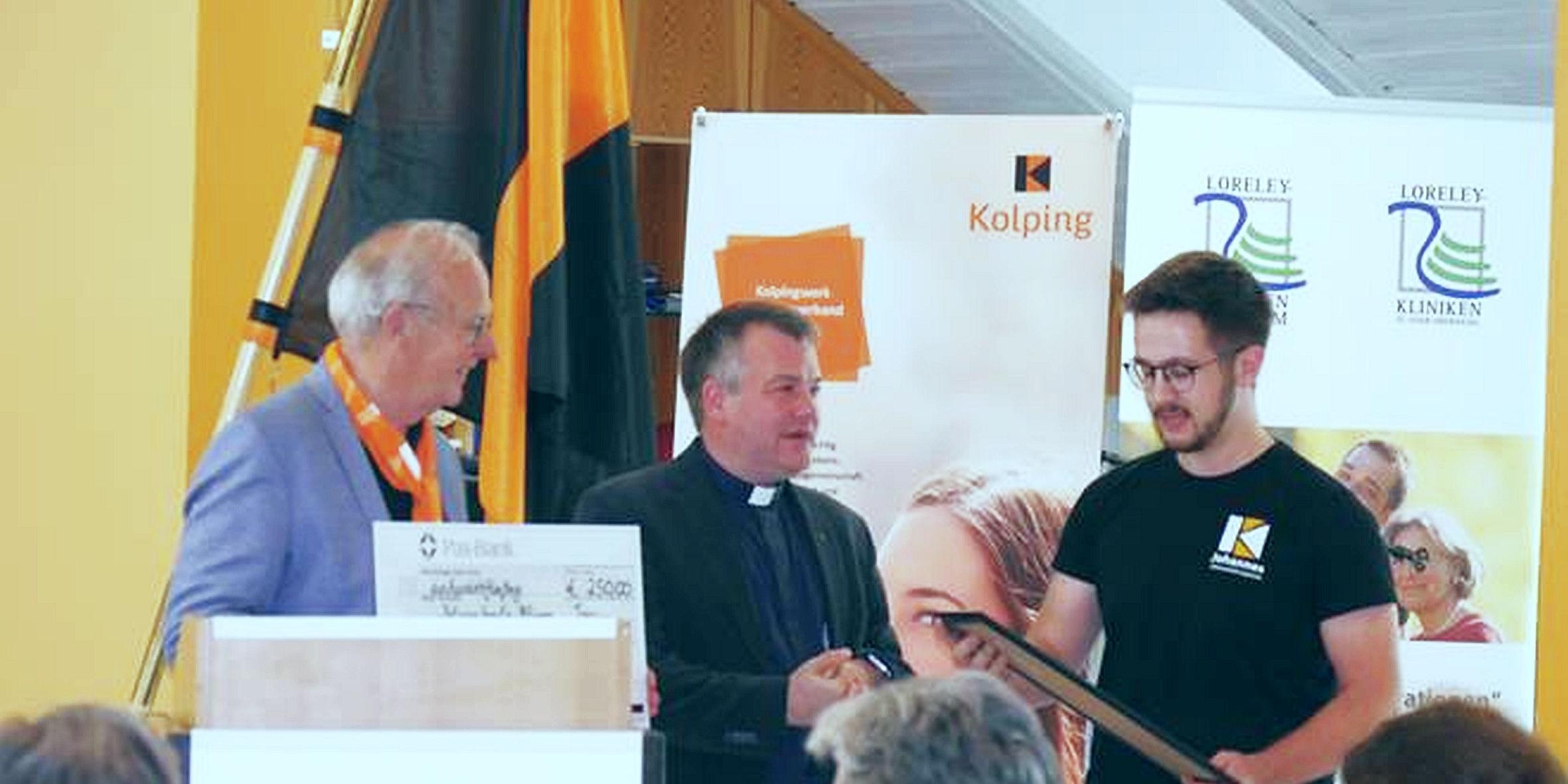 Dr. Bernd Geisen und Präses Christian Heinz vom Diözesanverband übergeben den Preis an Dominik Augustat (Kolpingjugend Illingen, von links).