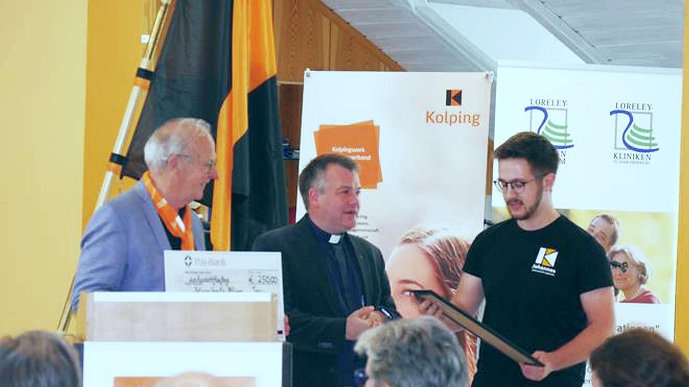 Dr. Bernd Geisen und Präses Christian Heinz vom Diözesanverband übergeben den Preis an Dominik Augustat (Kolpingjugend Illingen, von links).