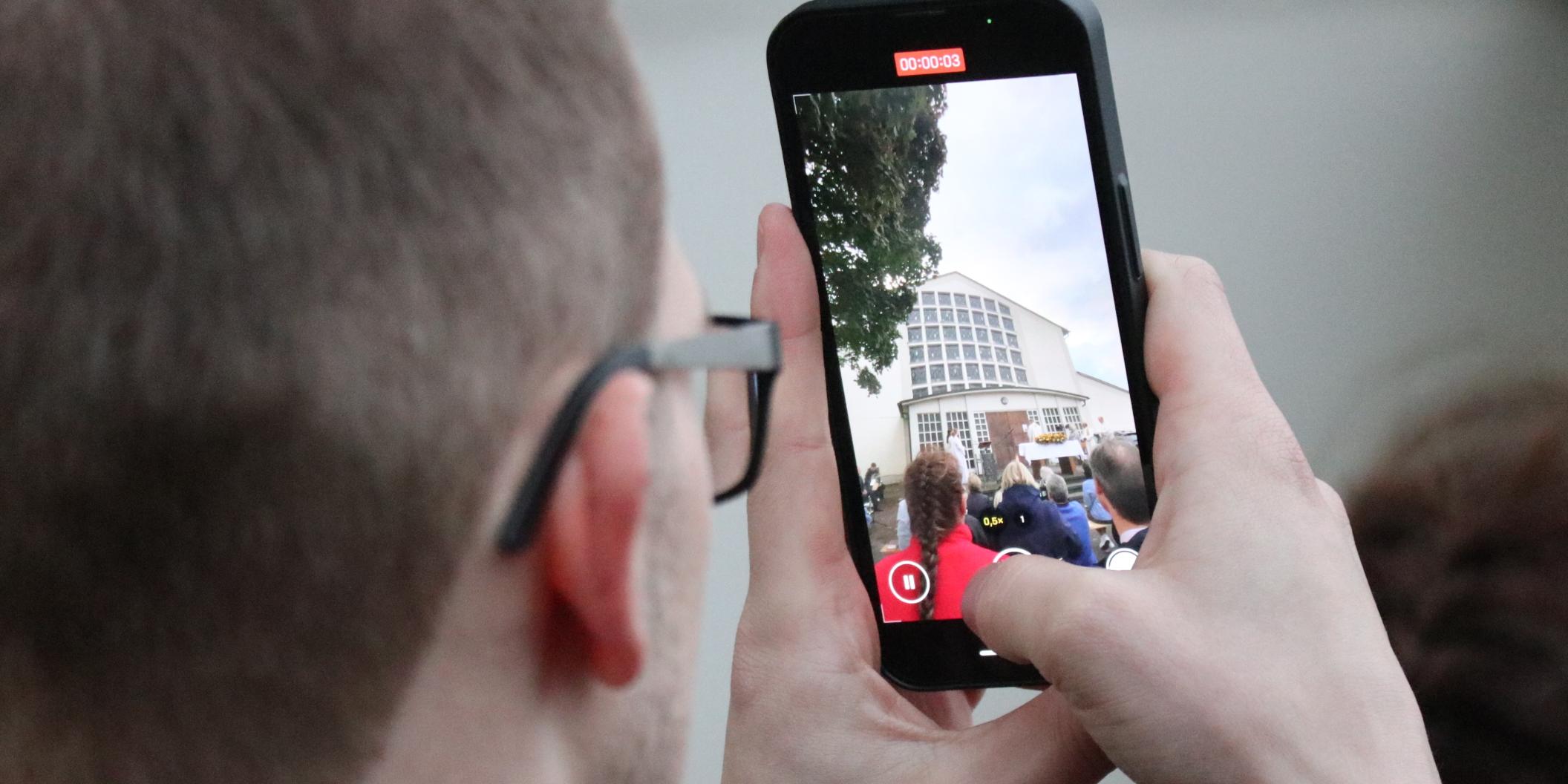 Viele Menschen halten den Moment mit dem Handy fest.