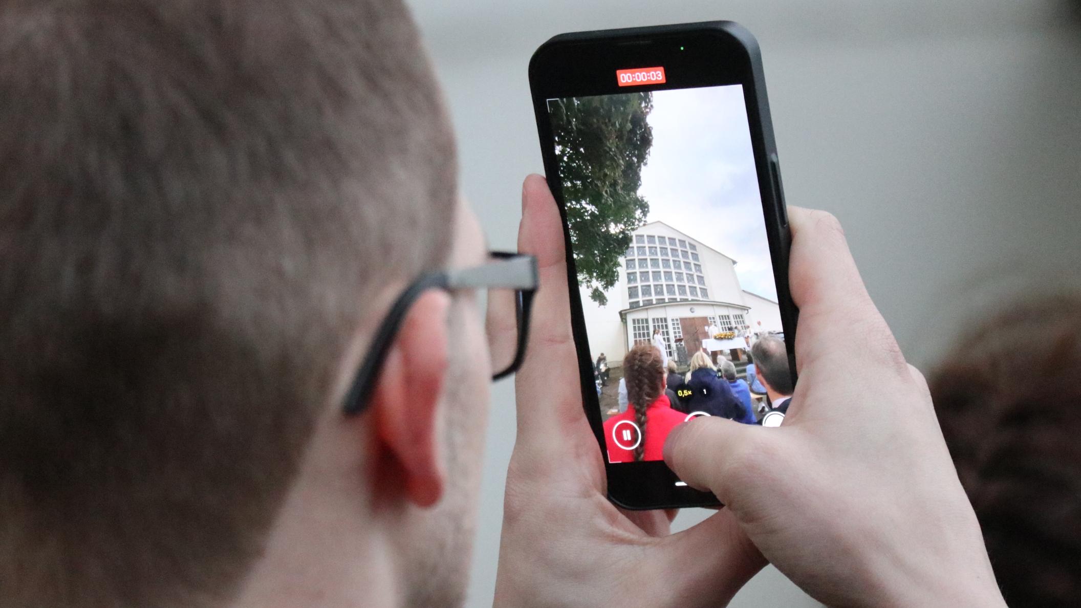 Viele Menschen halten den Moment mit dem Handy fest.