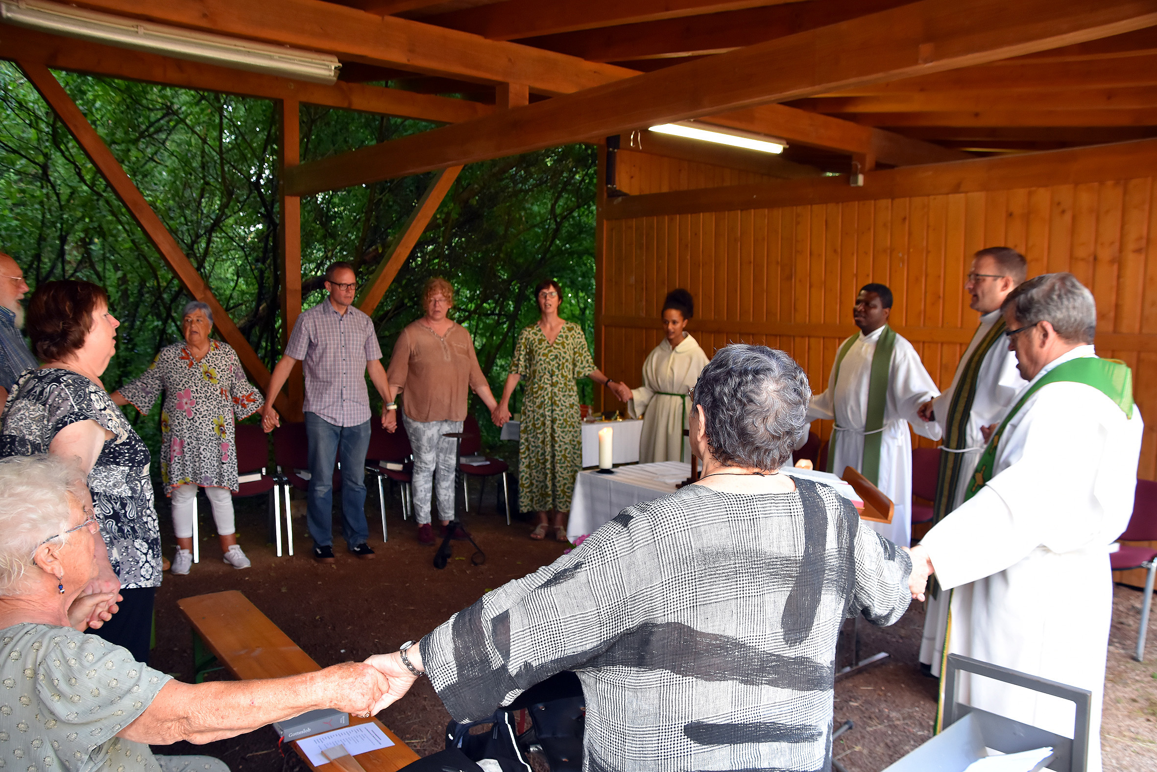 Aufgrund des Regens fand der Gottesdienst zur Profanierung im Carport neben dem Pfarrhaus statt.