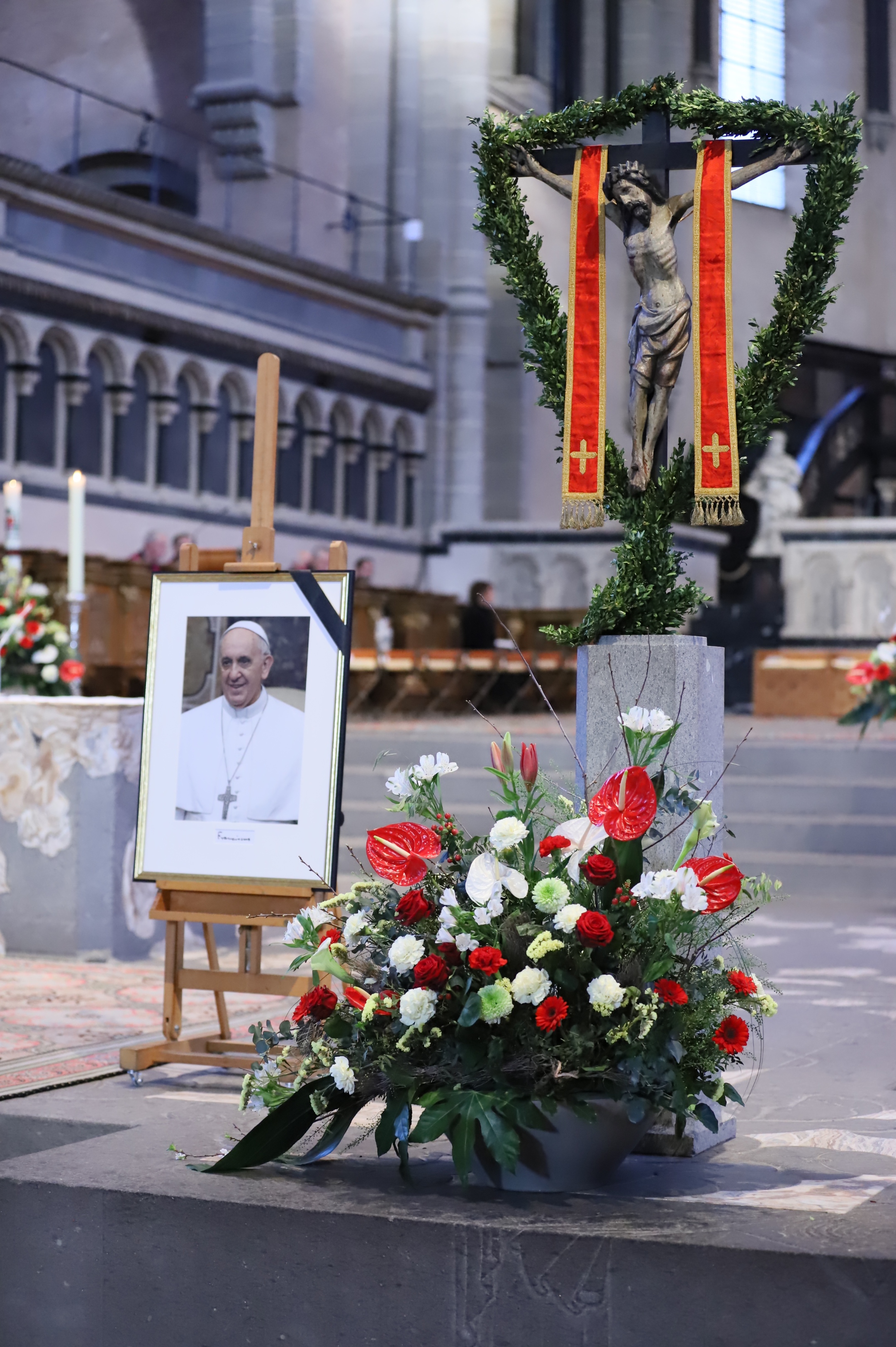 Ein Bild des verstorbenen Papstes stand neben dem geschmückten Osterkreuz.