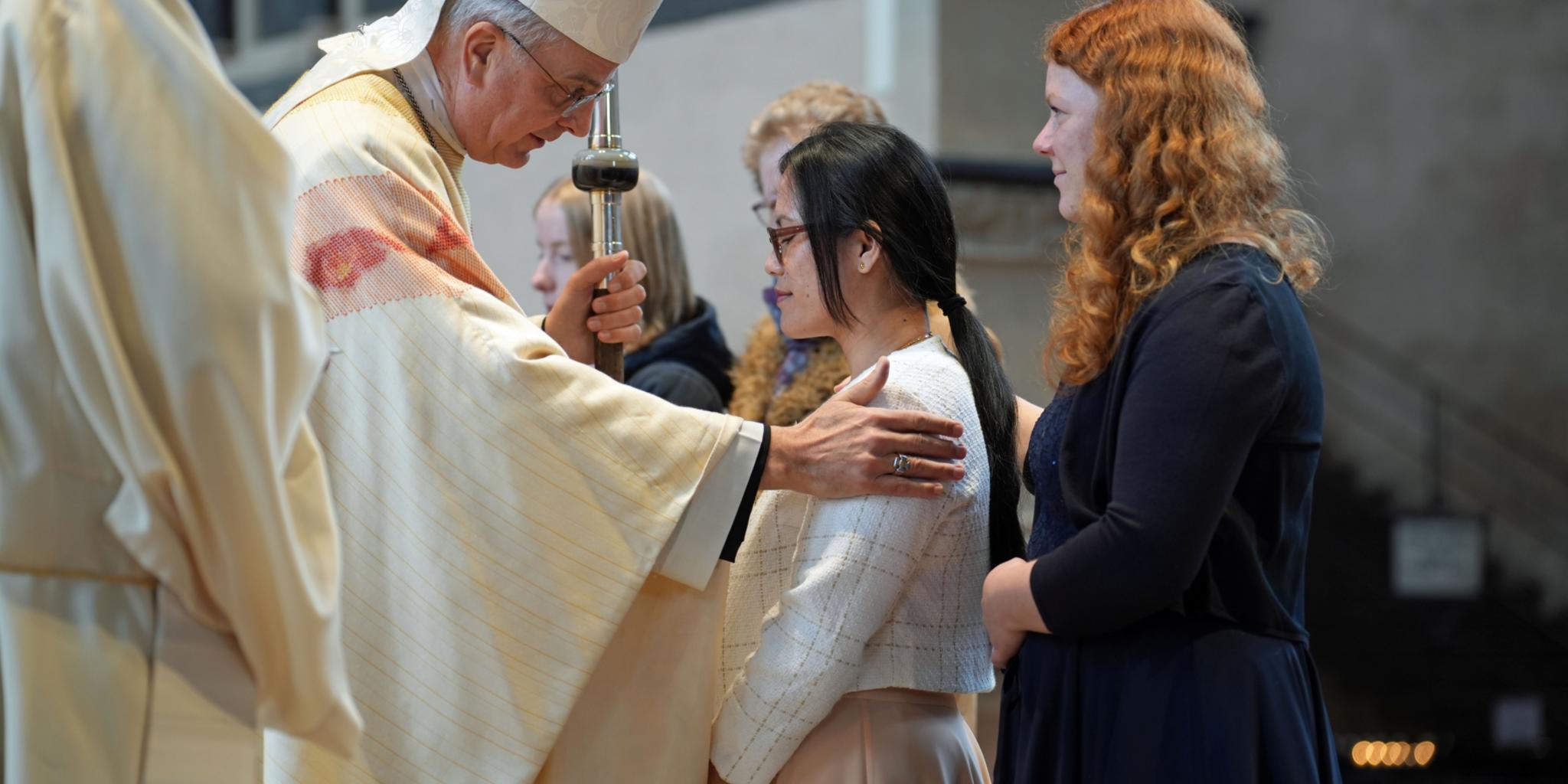 Weihbischof Jörg Michael Peters spendet einer jungen Frau das Sakrament der Firmung