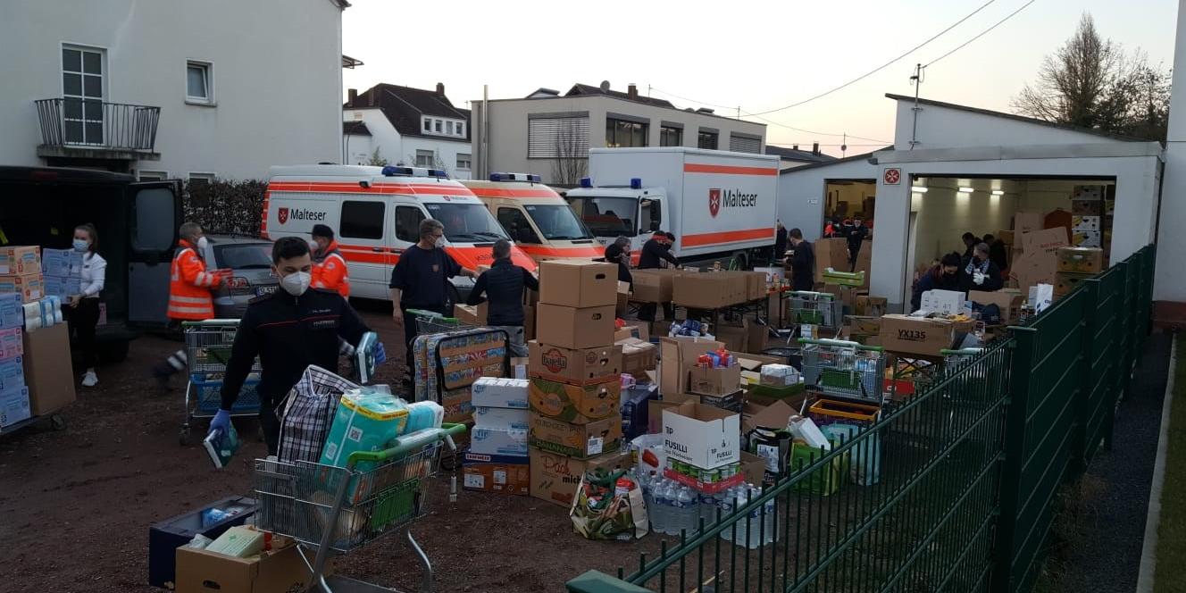 Mehrere Helfer der Malteser Trier vor einer großen LKW-Ladung an Sachspenden für die Ukraine.