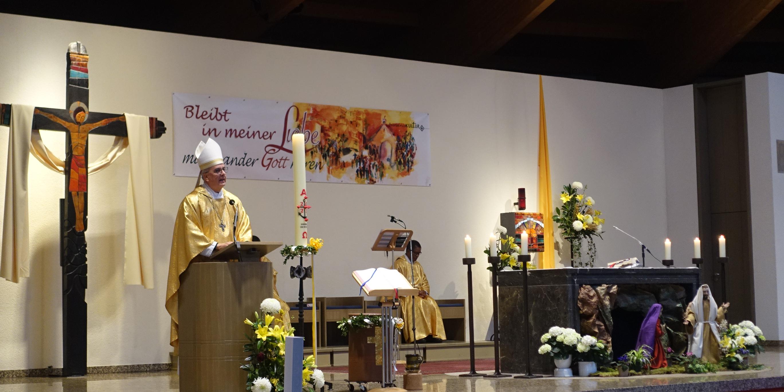 Weihbischof Peters steht an einem Altar zur Gemeinde gewandt.