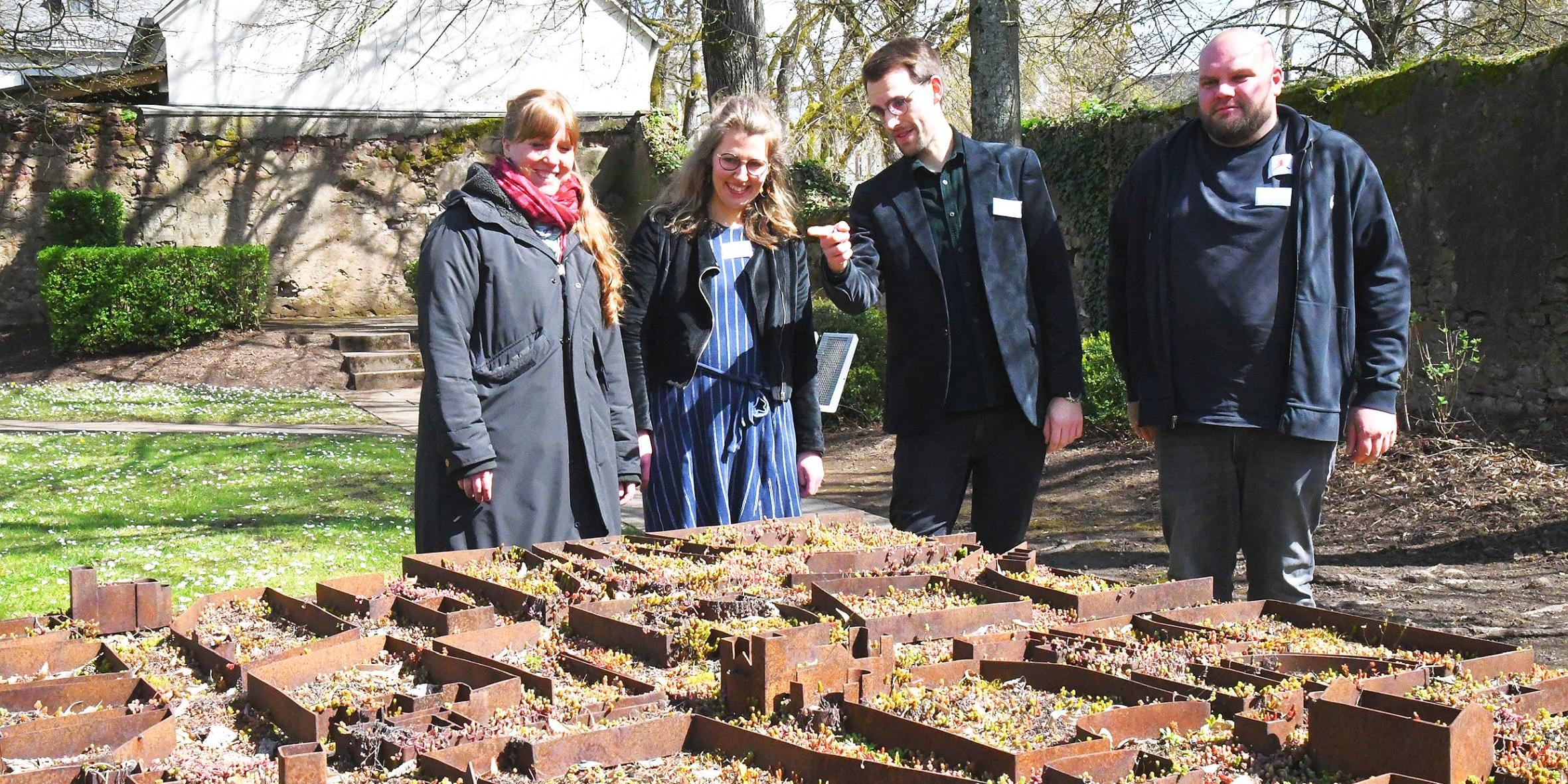 Sophie Lungershausen, Julia Raser und Adrian Schneider von der LA 21 mit Florian Probst (Vereinigte Hospitien, von links) an einem Stadtmodell.