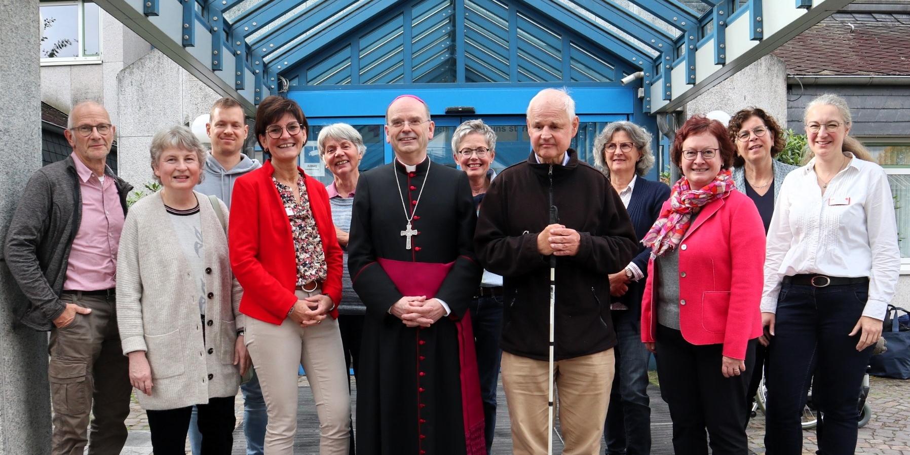 Weihbischof Robert Brahm (Mitte) tauscht sich mit ehrenamtlichen „Grünen Damen und Herren“ im DRK Krankenhaus Kirchen aus. Es fehlen auf dem Foto weitere langjährige Ehrenamtliche.