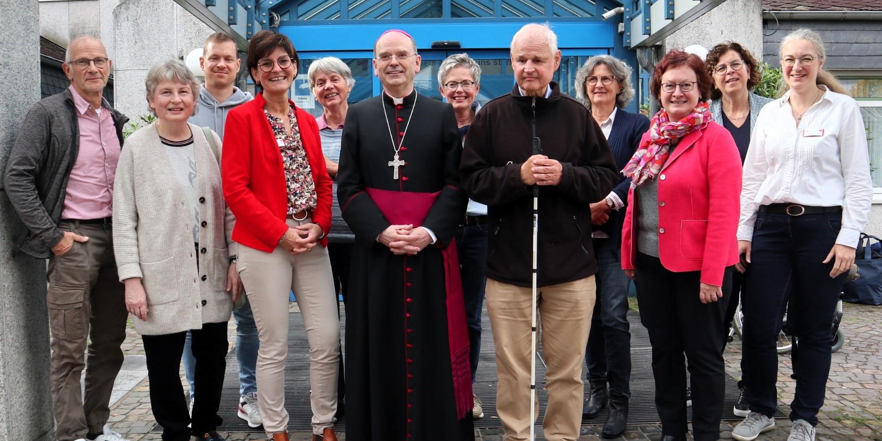 Weihbischof Robert Brahm (Mitte) tauscht sich mit ehrenamtlichen „Grünen Damen und Herren“ im DRK Krankenhaus Kirchen aus. Es fehlen auf dem Foto weitere langjährige Ehrenamtliche.