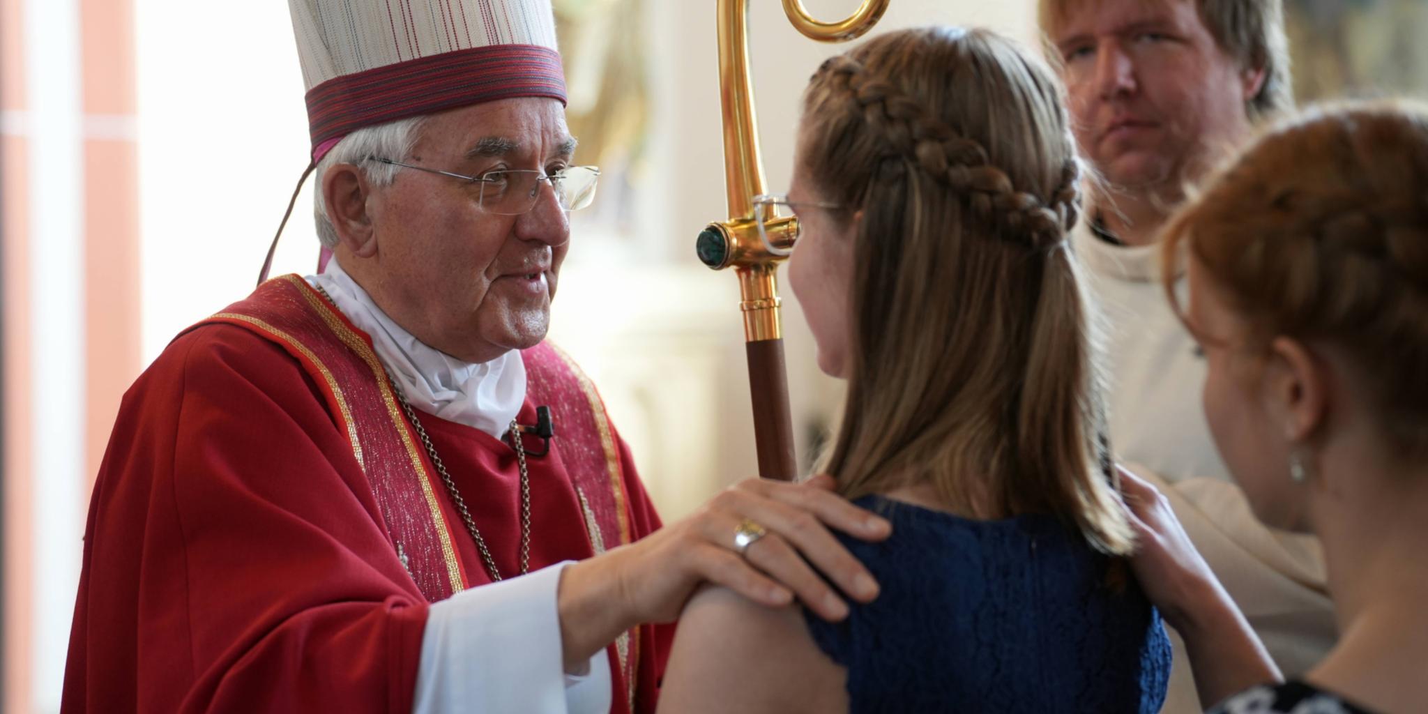 Der Weihbischof spendet den jungen Menschen beim Firmgottesdienst in Kirn das Sakrament, dass sie mit dem Heiligen Geist bestärkt.