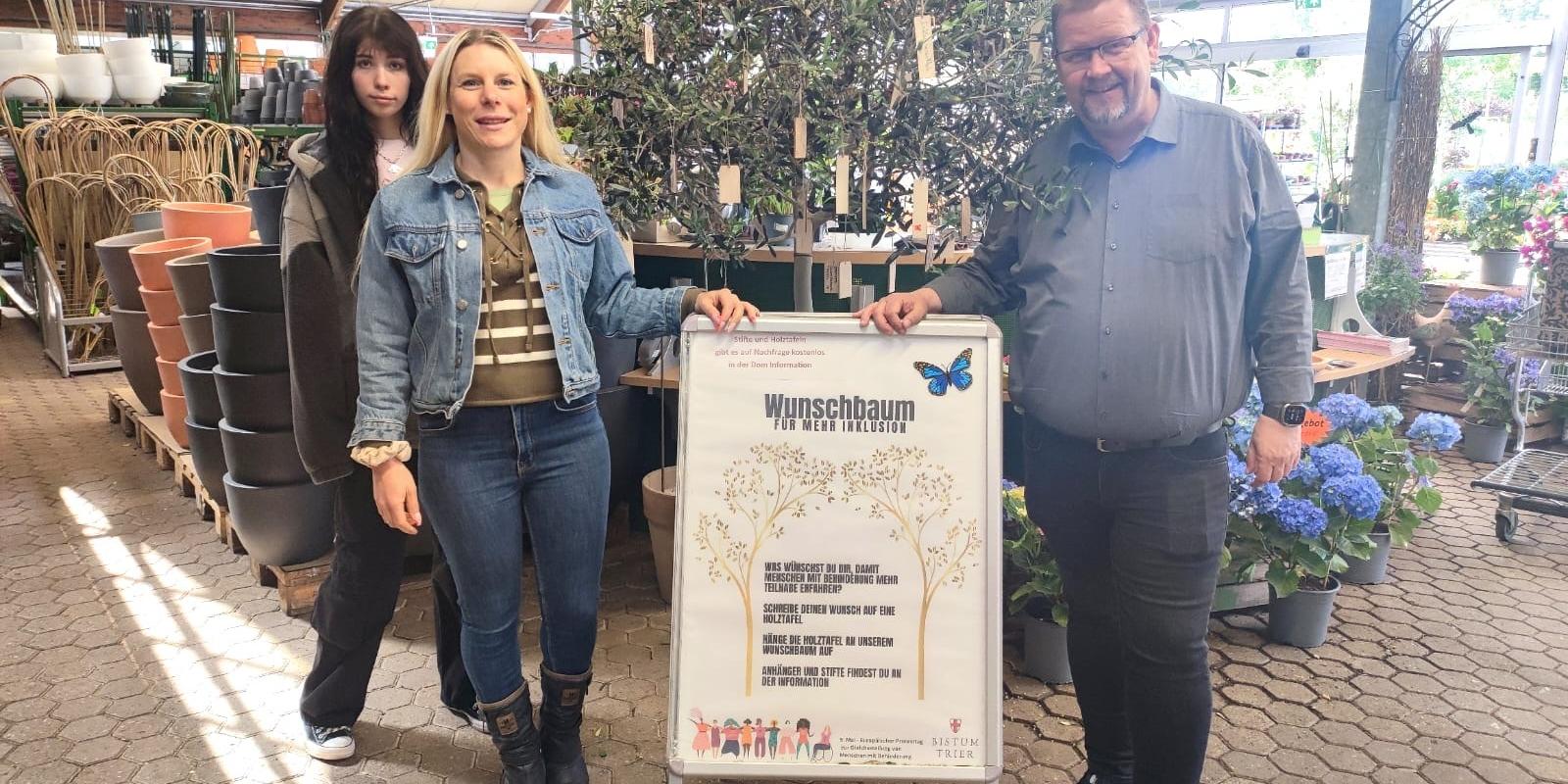 Die Tonpost im Gartenzentrum:  Emily Reimann, FSJlerin in der Tonpost, Kathrin Schmitt, Leiterin der Tonpost und Martin Oed, Geschäftsführer Lambert, haben mit dem Wunschbaum ein Zeichen für mehr Inklusion gesetzt.