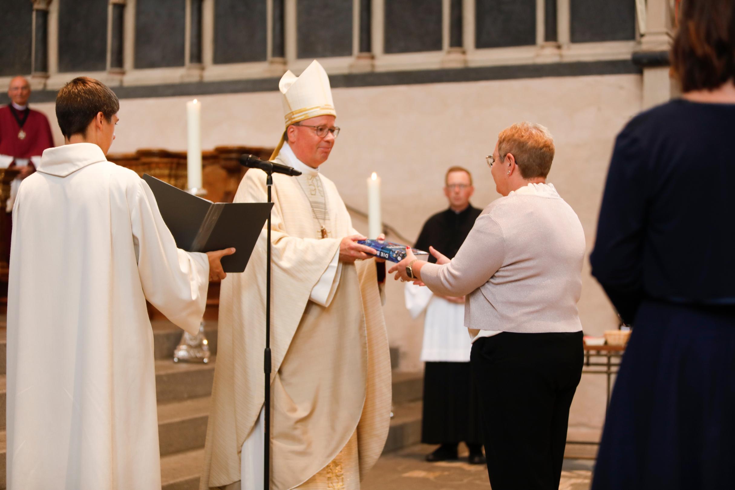 Bischof Ackermann überreicht Sandra Ackermann eine Bibel