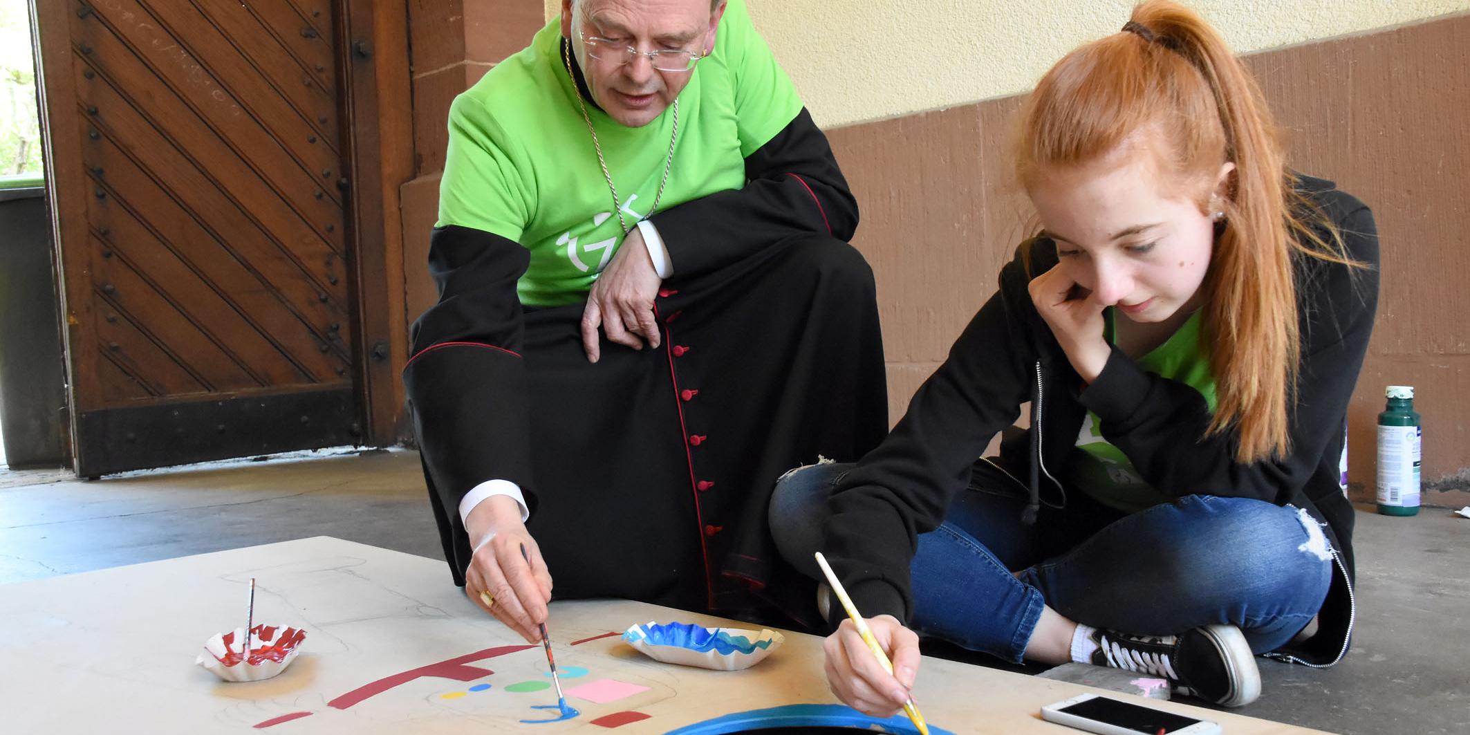 Weihbischof Robert Brahm hat sich bei seinem Besuch selbst einen Pinsel geschnappt und den Jugendlichen geholfen. (Foto: Hans Georg Schneider)