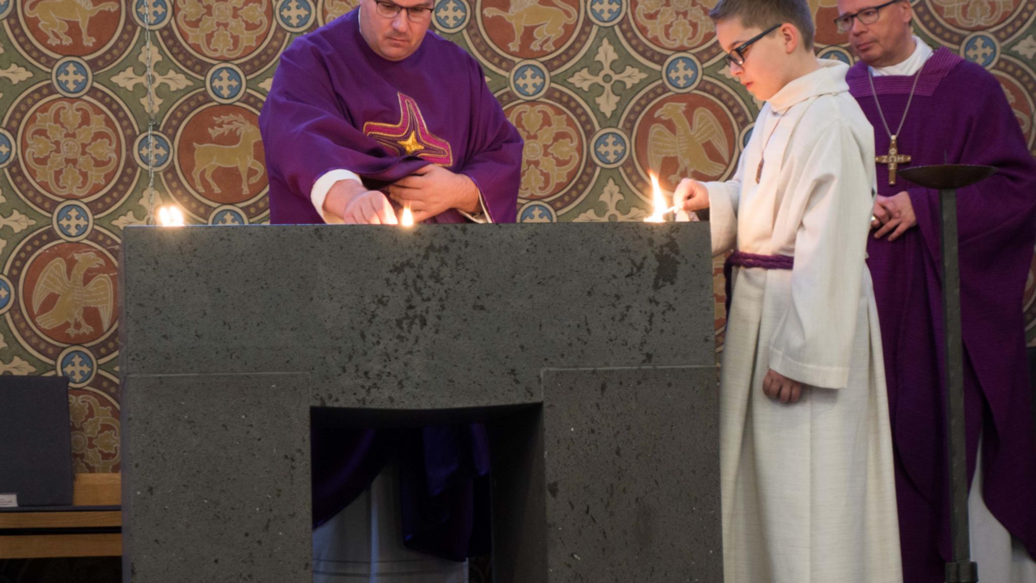 Pastor Jörg Schuh (Mitte) entzündet gemeinsam mit einem Messdiener Weihrauch auf dem neuen Altar.