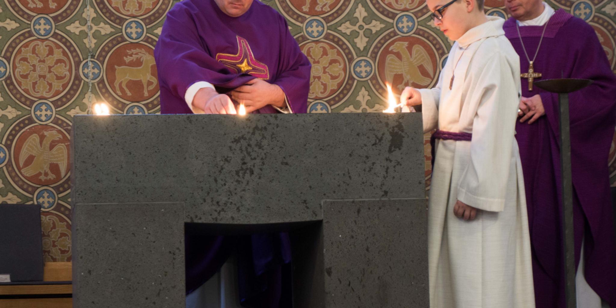 Pastor Jörg Schuh (Mitte) entzündet gemeinsam mit einem Messdiener Weihrauch auf dem neuen Altar.