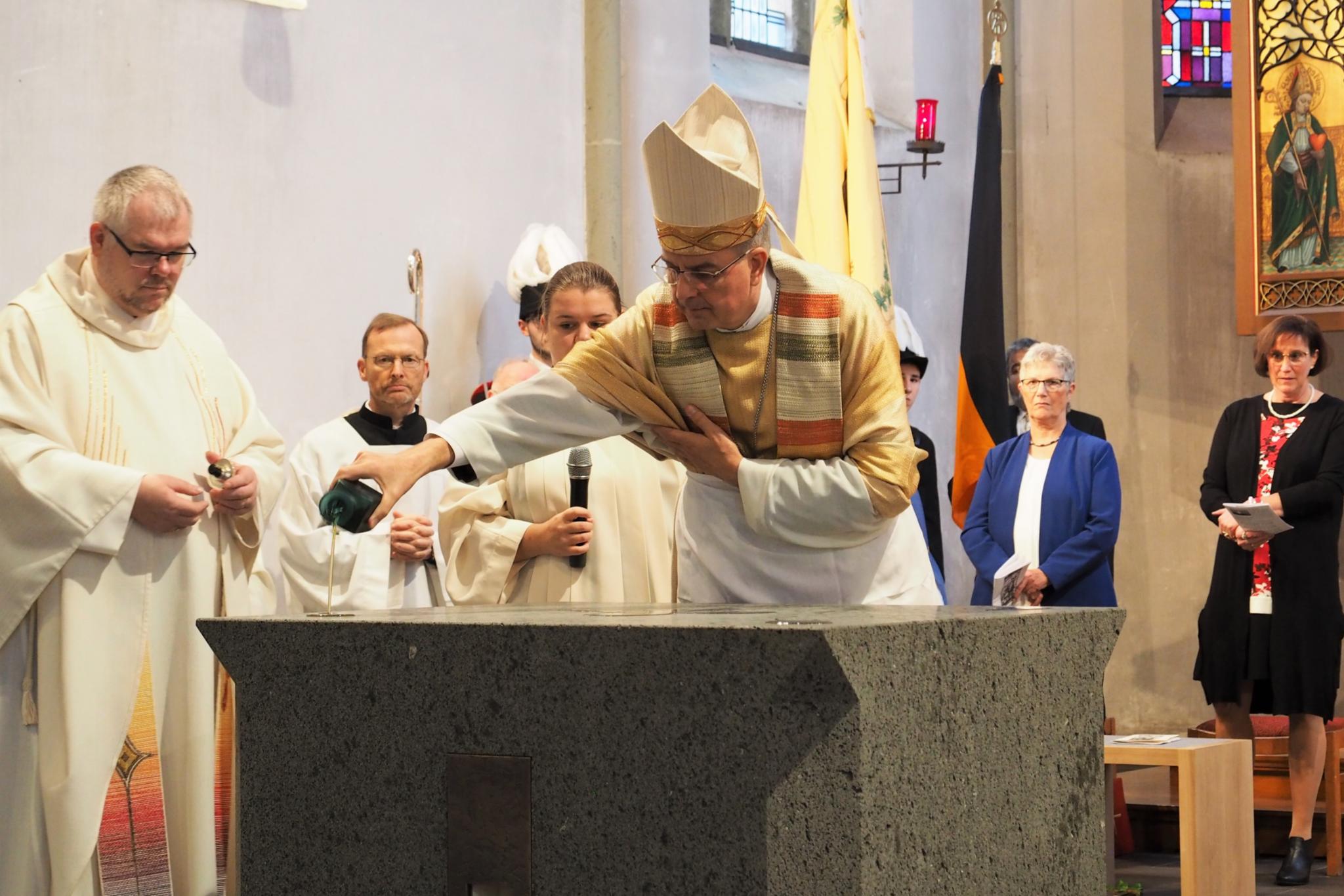 Weihbischof Jörg Michael Peters begießt die Altarfläche mit Chrisamöl.