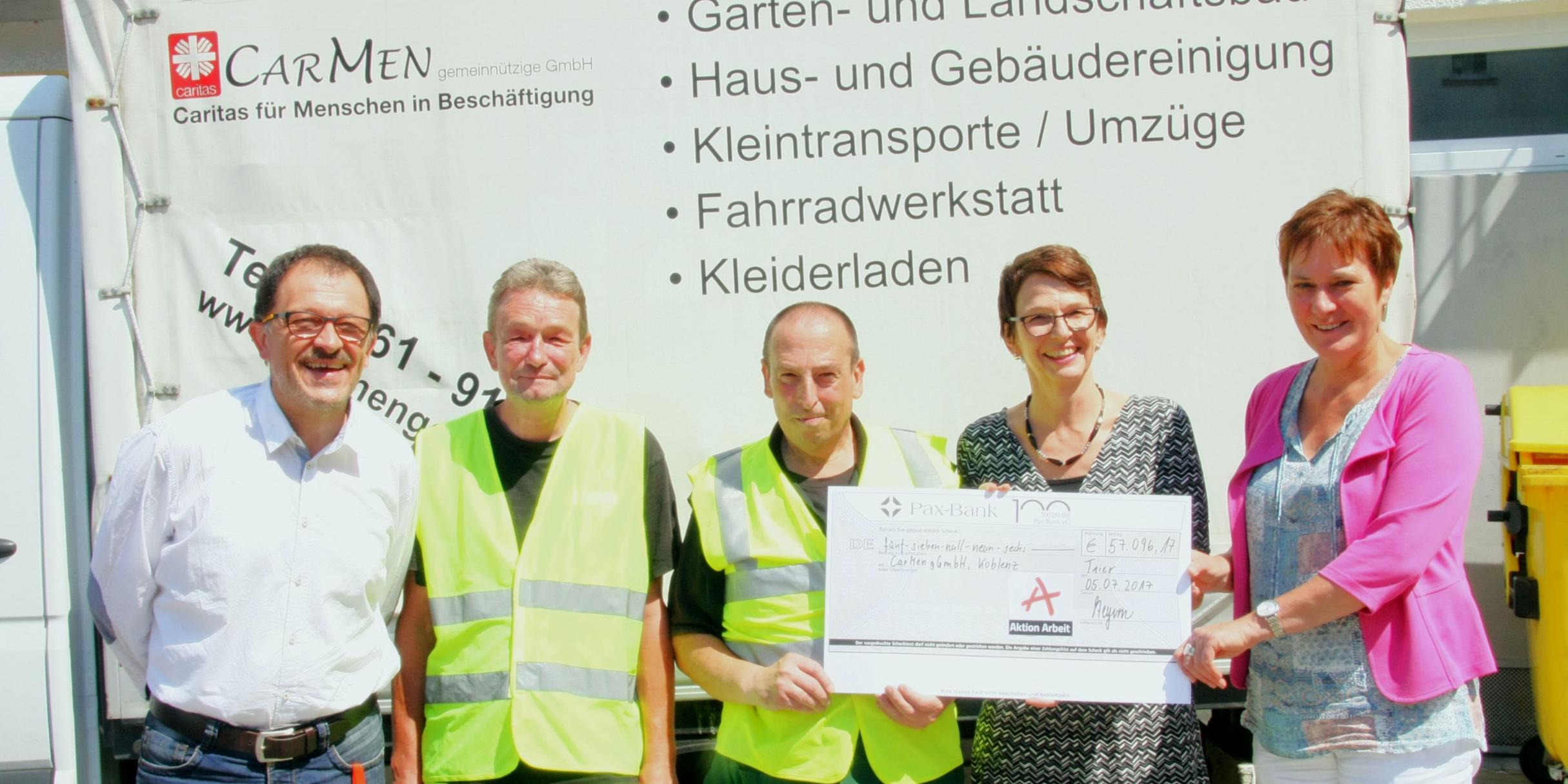 Die Direktorin des Caritasverbands Koblenz Martina Best-Liesenfeld (rechts) und der Geschäftsführer von CarMen Hermann Trapp (links) freuen sich über die Förderung der Aktion Arbeit, den die Geschäftsführerin Andrea Steyven in Form eines Schecks übergibt.