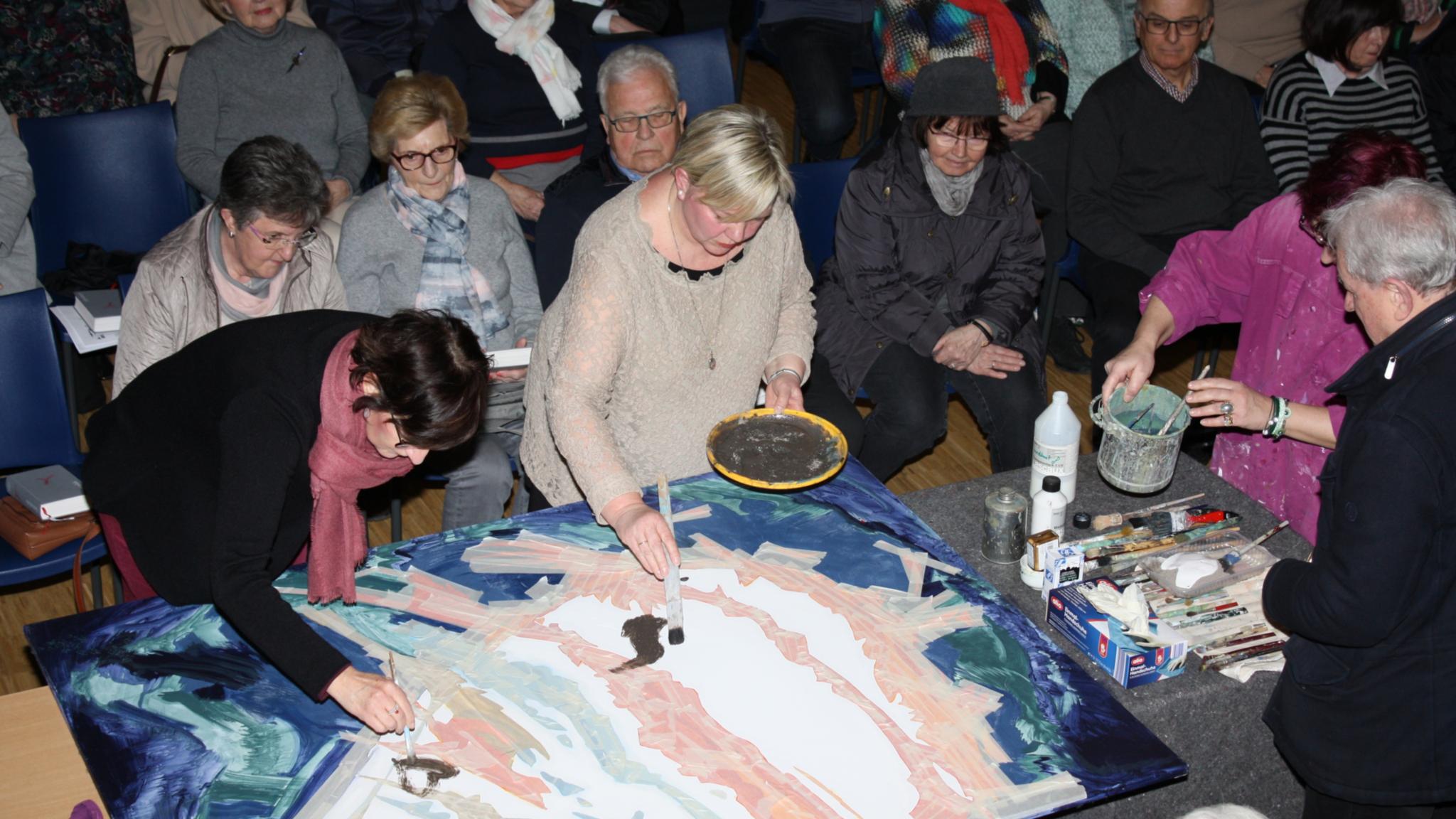 Gemeinsam mit den Gottesdienstbesuchern wird mit Asche ein herzförmiges Bild gestaltet.