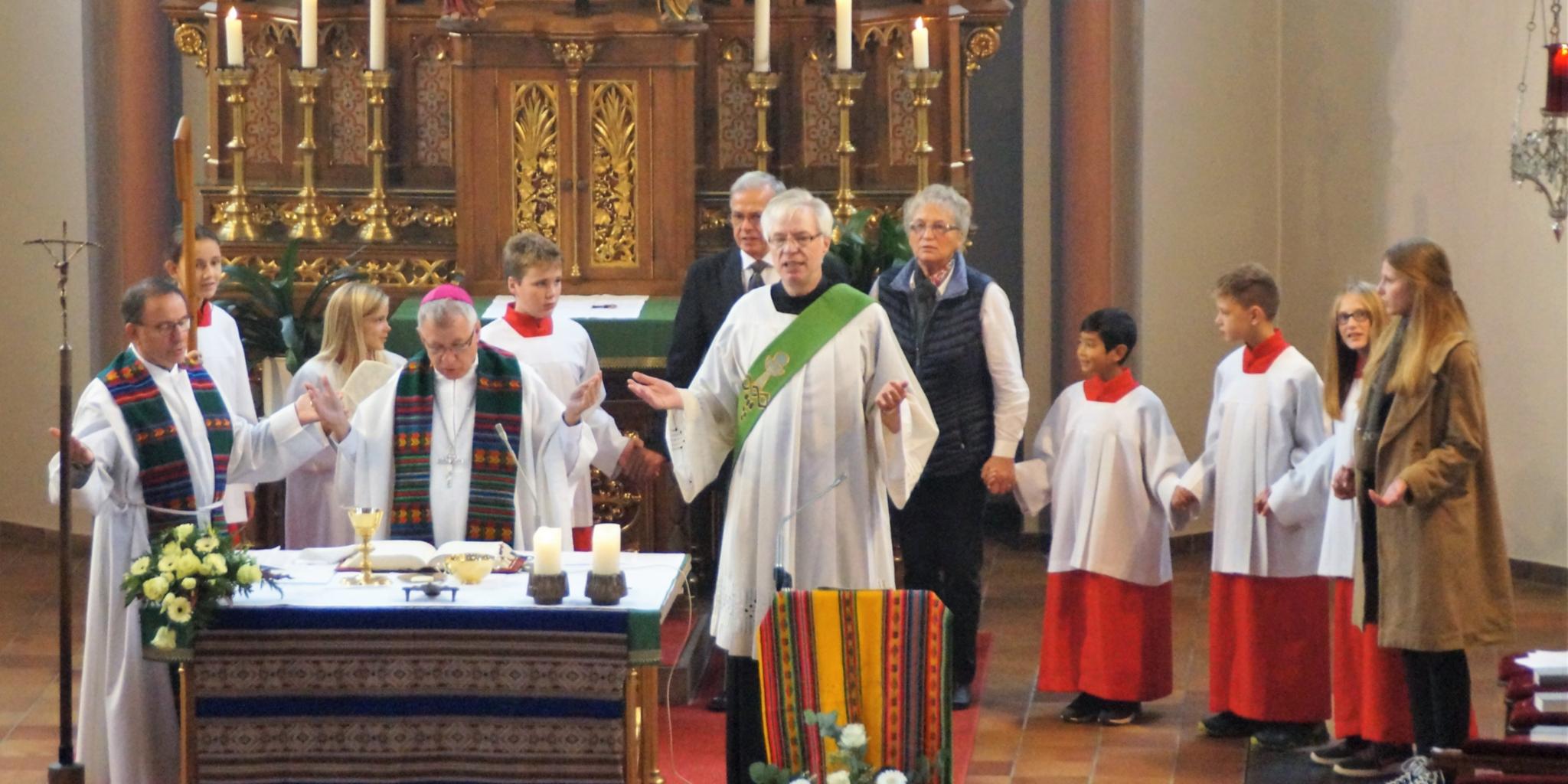 Eingerahmt von Pfarrer Jonas Weber und Diakon Herbert Knobloch betet Bischof Flock mit der Gemeinde das Vaterunser.