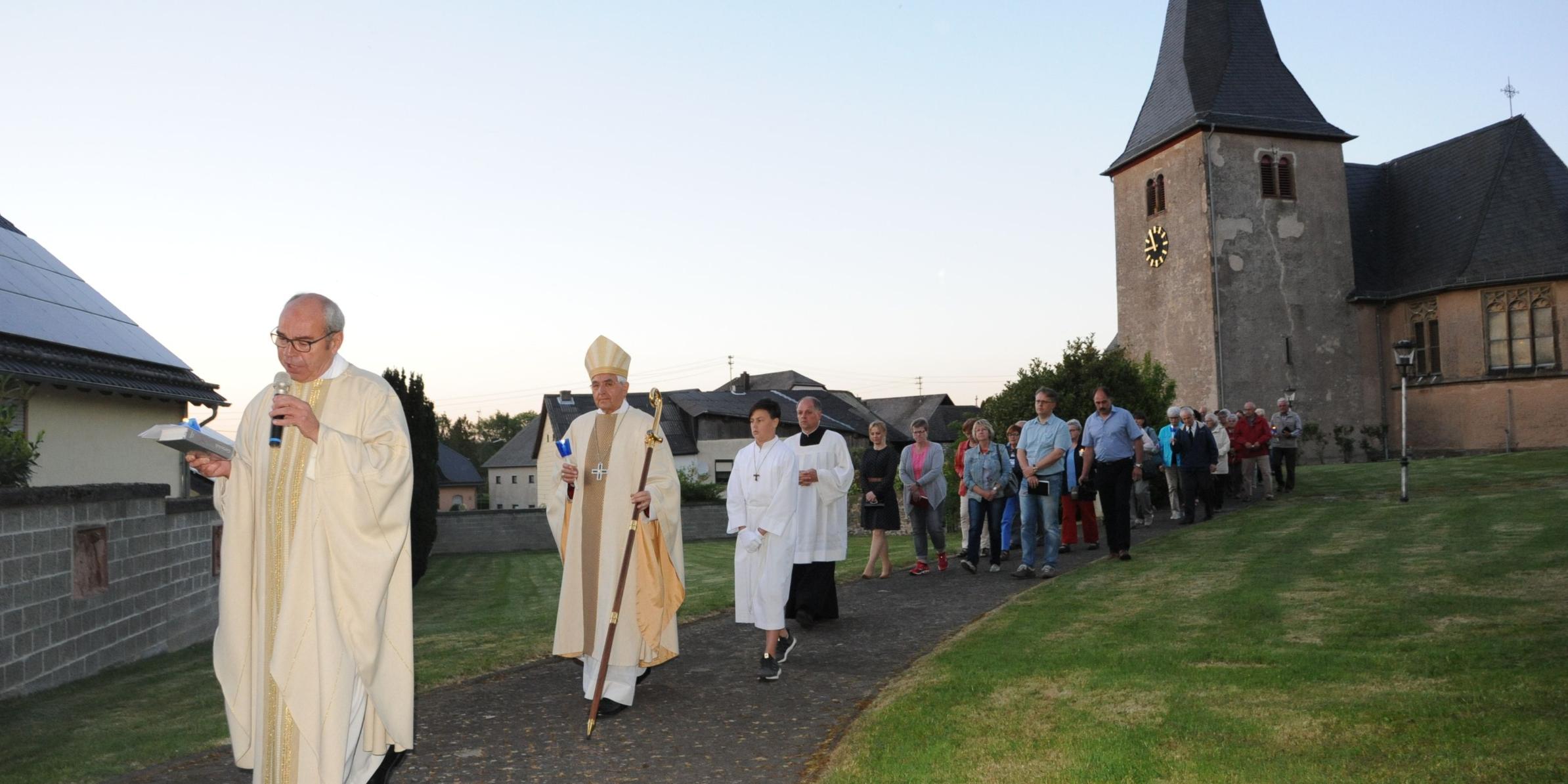 Weihbischof Franz Josef Gebert und Dechant Georg Moritz (vorne) bei der Lichterprozession um die Berglichter Wallfahrtskirche Maria Geburt.