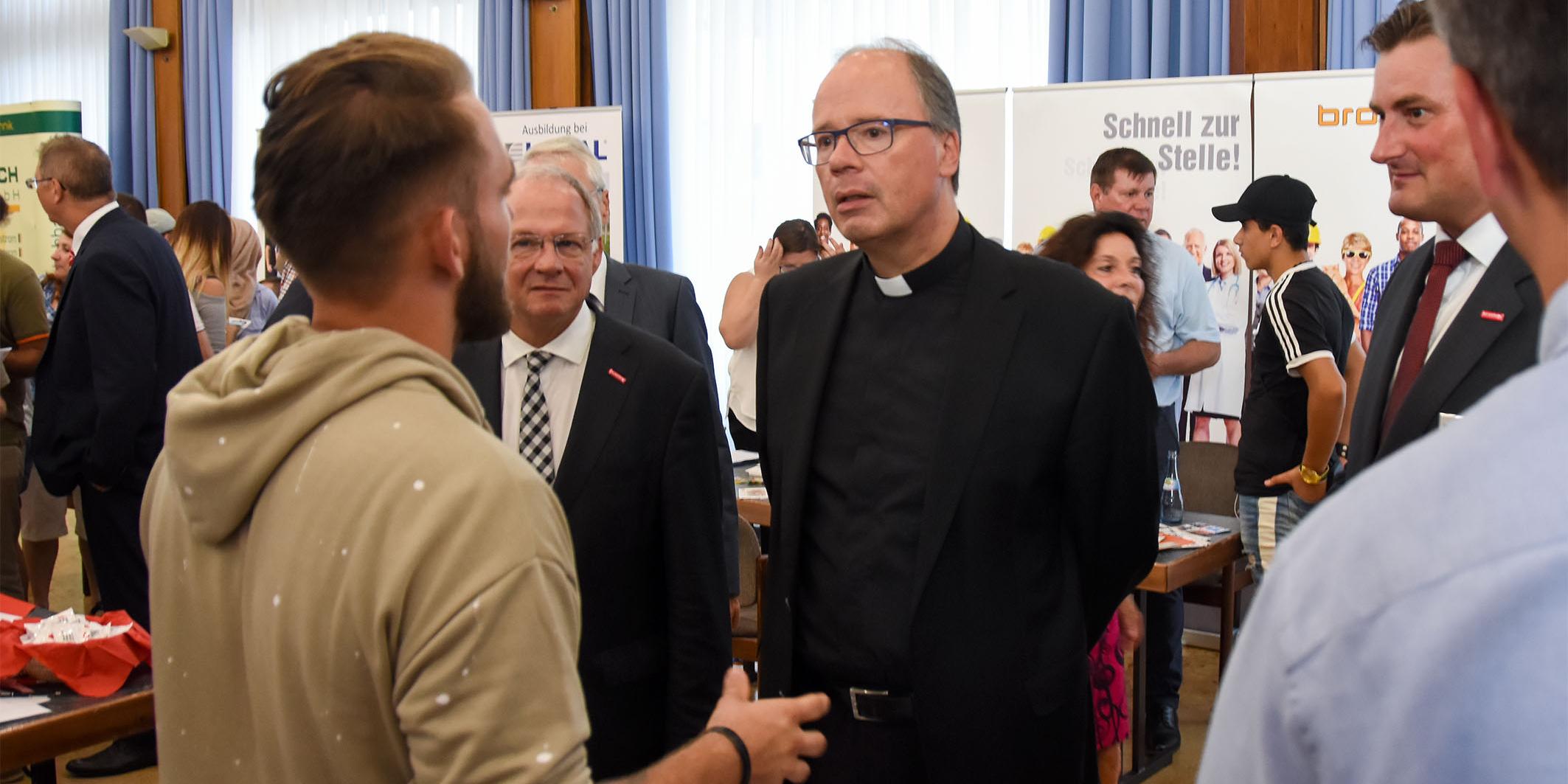 Bischof Ackermann in Begleitung vom Präsidenten der Handwerkskammer Bernd Wegner MdL im Gespräch mit einem der Aussteller auf der Jobbörse.