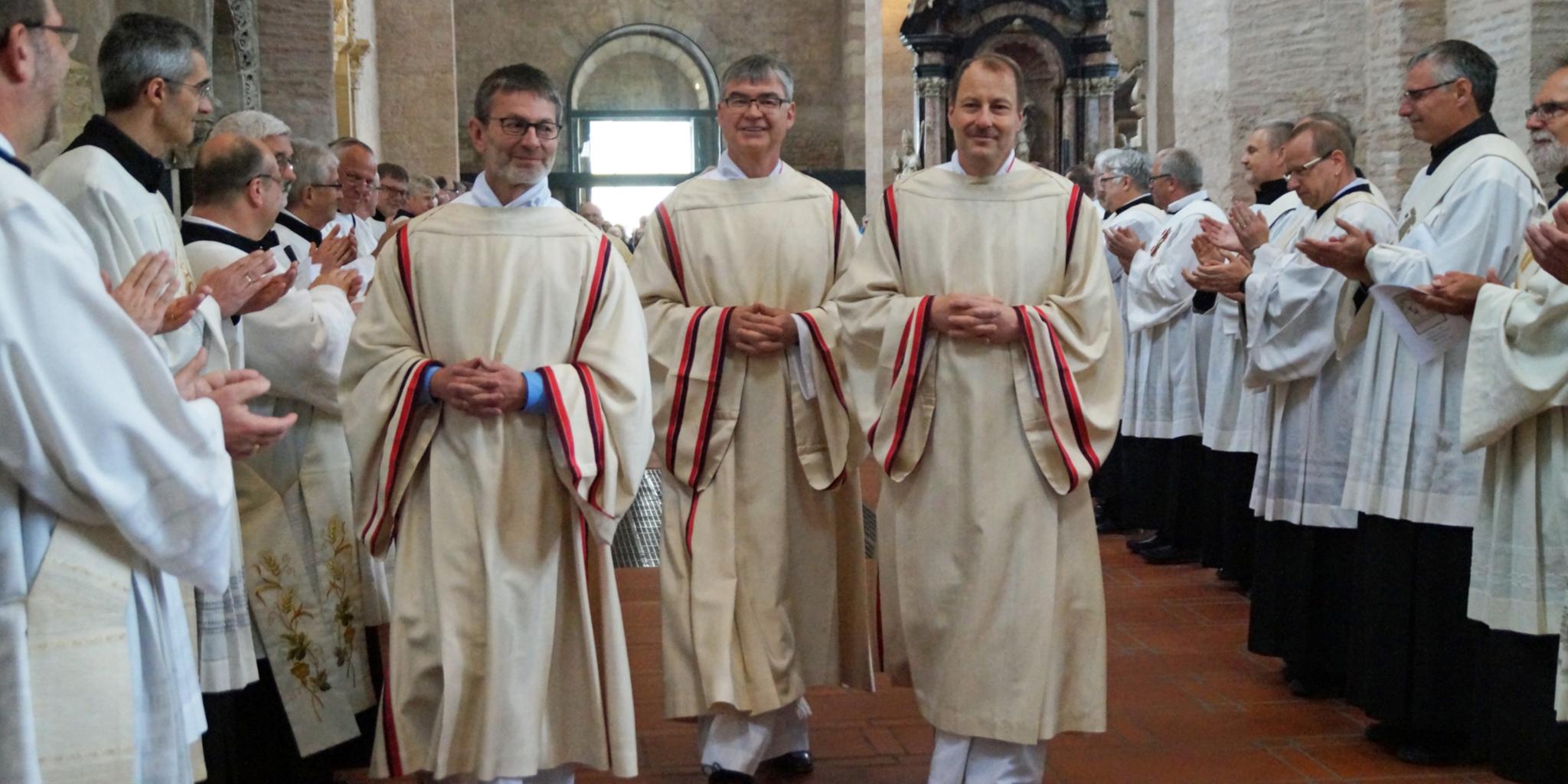 Unter dem Beifall ihrer Kollegen ziehen die neuen Diakone Peter Krämer, Stefan Leinenbach und Sebastian Pollitt (von links) nach ihrem festlichen Weihegottesdienst aus dem Dom aus.