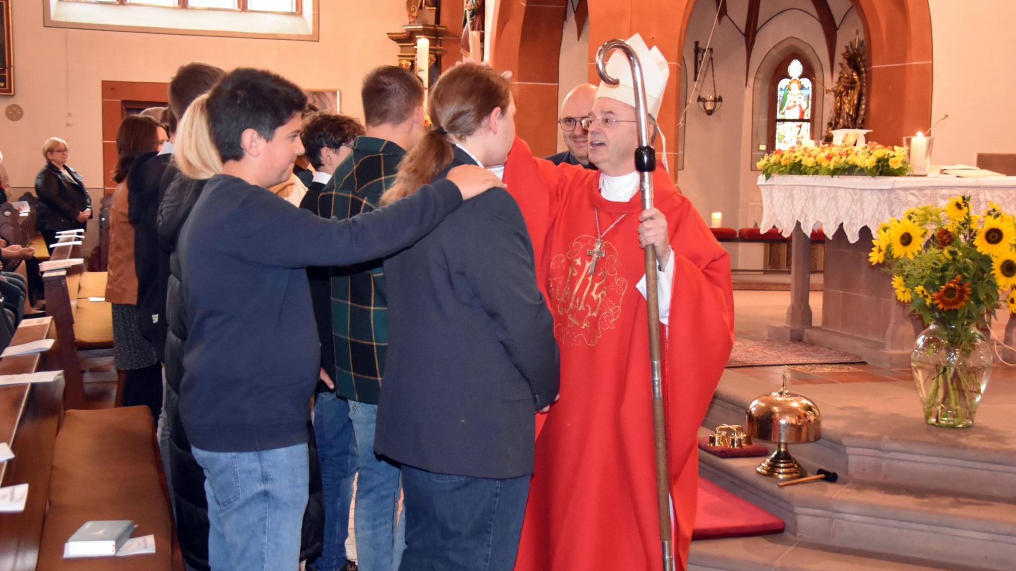 Weihbischof Robert Brahm spendet Jugendlichen das Sakrament der Firmung in der Pfarrkirche St. Willibrord in Schmelz-Limbach. Foto: Ute Kirch