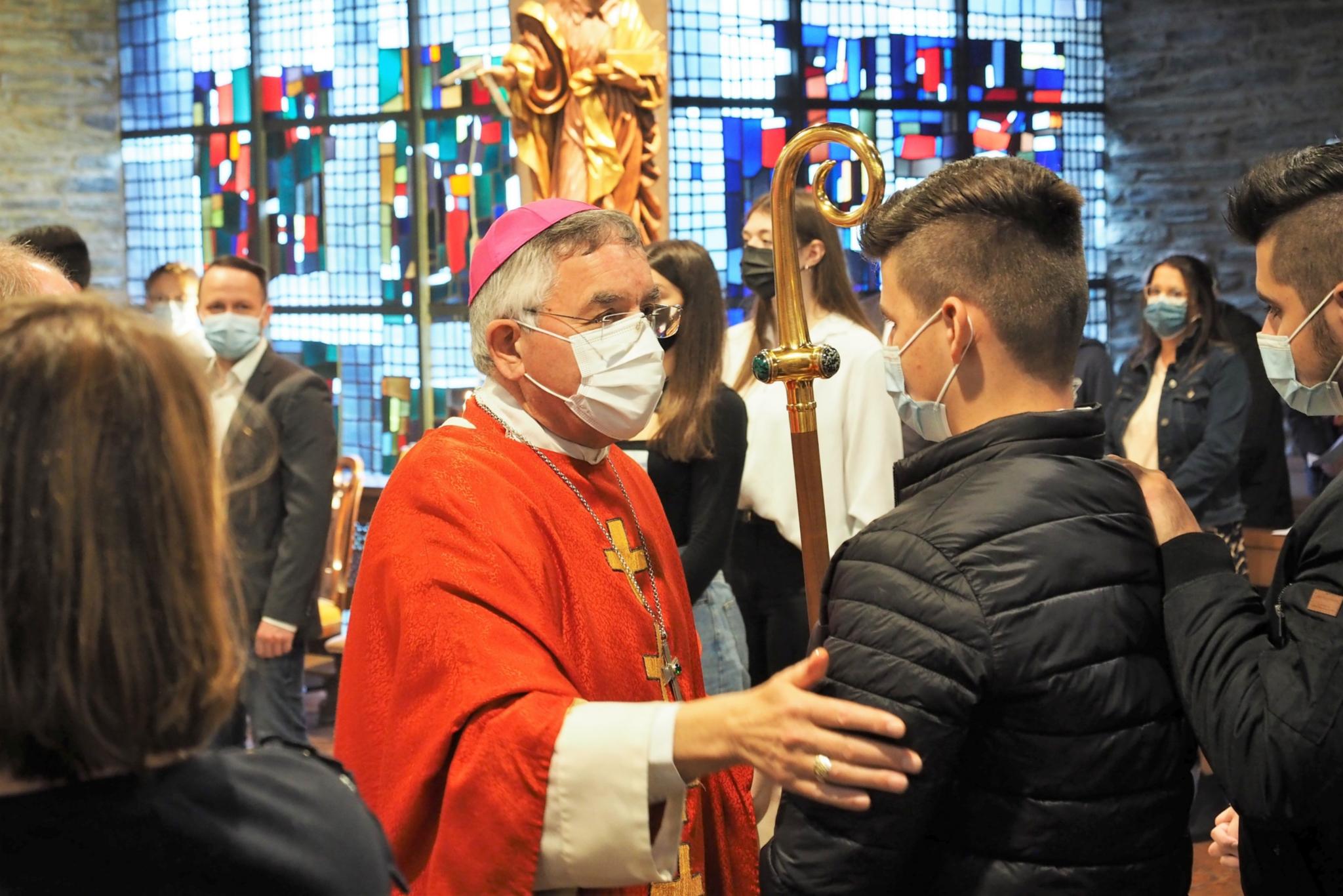 Weihbischof Gebert spendet einem jungen Erwachsenen das Sakrament der Firmung