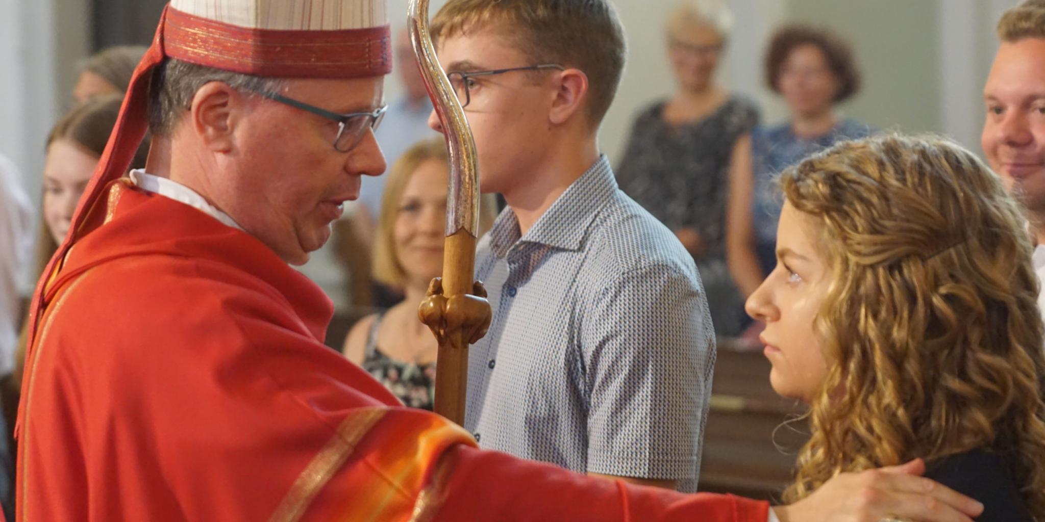 Bischof Ackermann spendet Charlotte Klos das Sakrament der Firmung. Foto: Heribert Schmitt