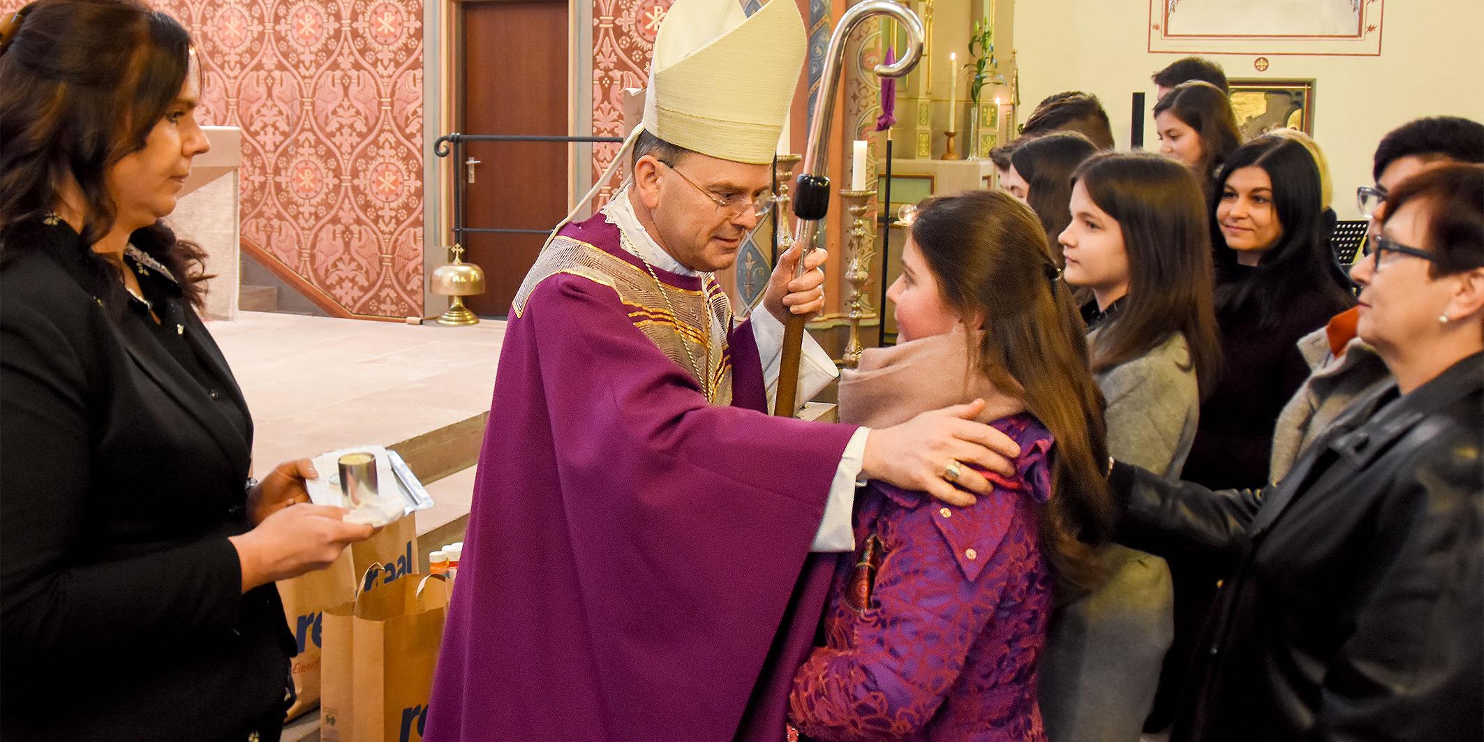 Weihbischof Robert Brahm spendet das Sakrament der Firmung