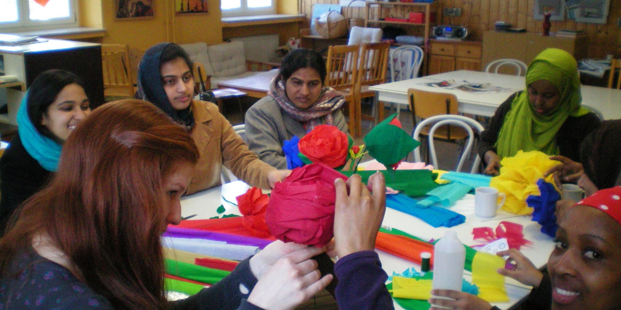 Flüchtlingsfrauen beim Basteln von Papierblumen