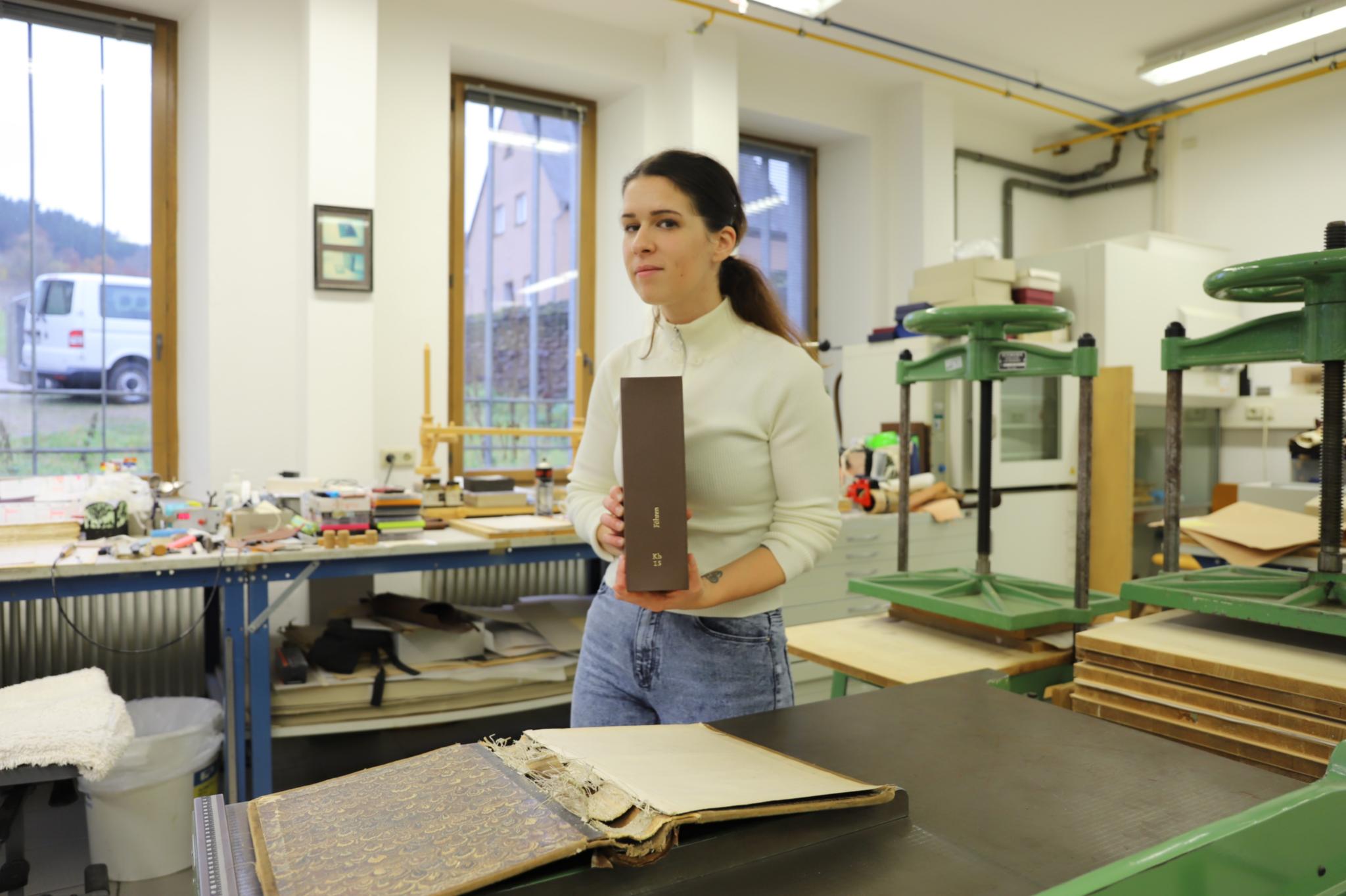 Sabine Golinski zeigt ein Kirchenbuch aus der Pfarrei Föhren, das sie wieder benutzbar gemacht hat.