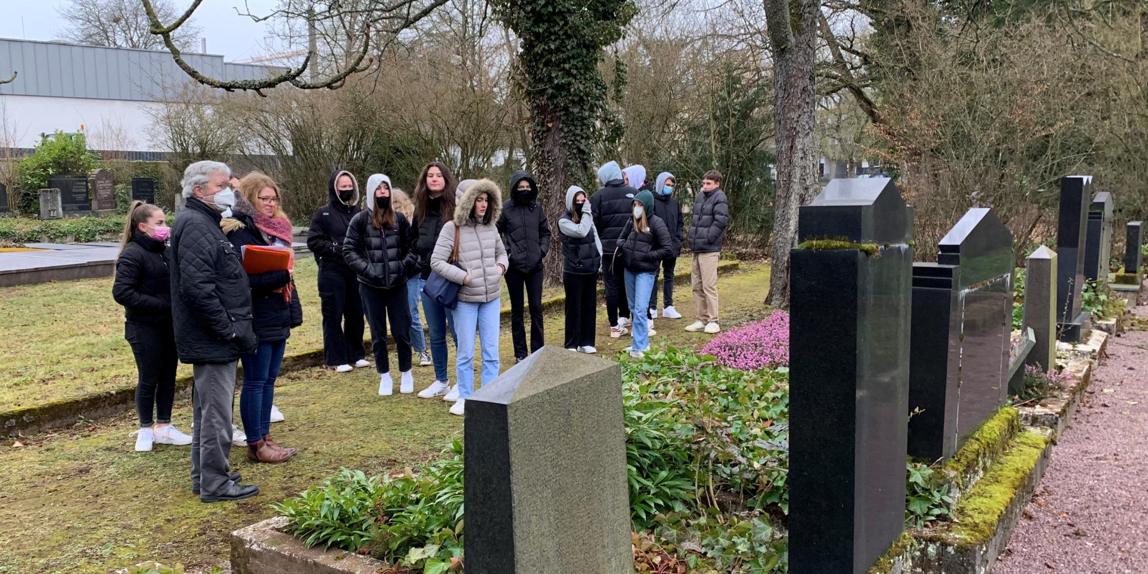 Schülerinnen und Schüler des Stadtgarten-Gymnasiums gedenken auf dem jüdischen Friedhof in Saarlouis der Opfer des Nationalsozialismus. Foto: Ute Kirch
