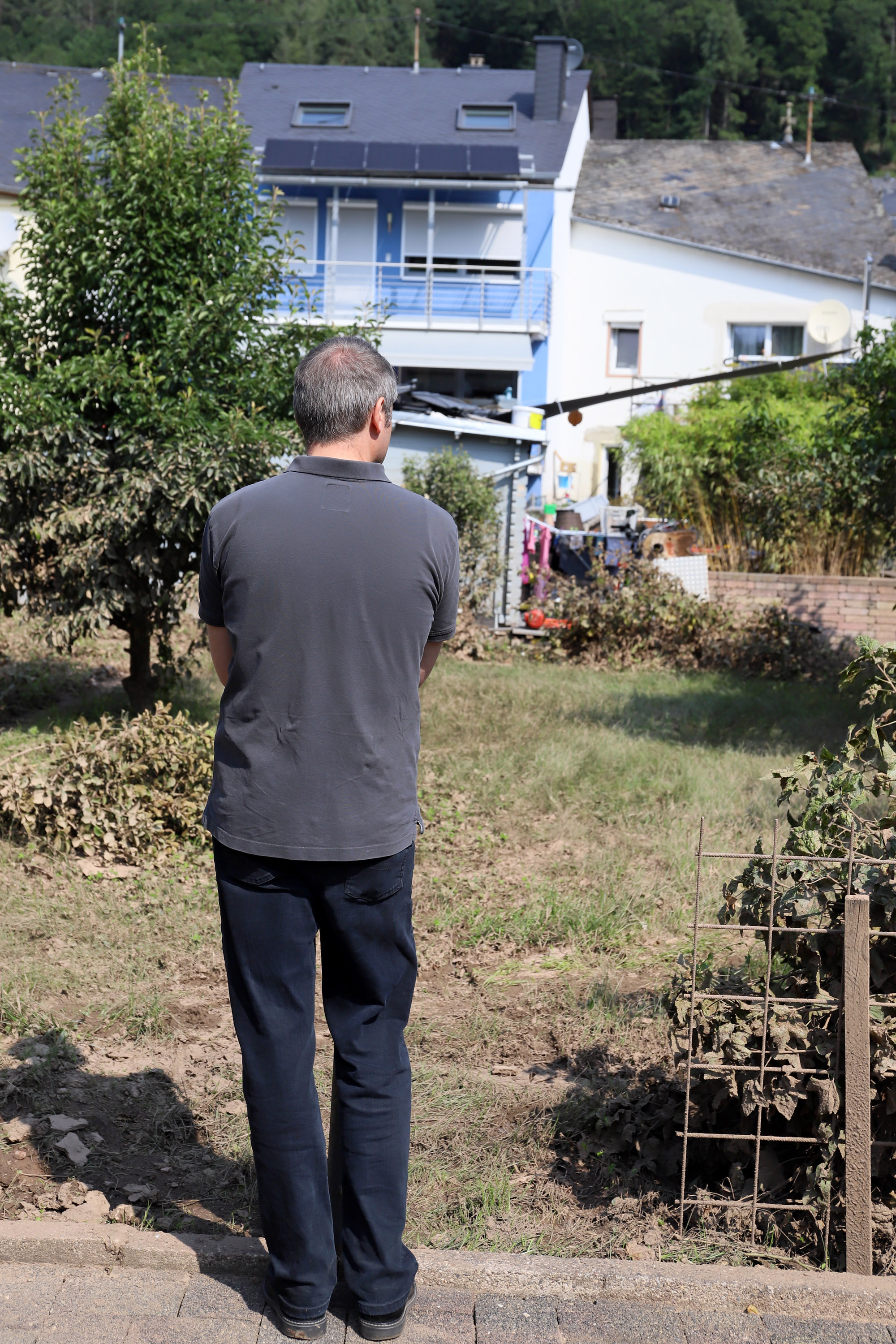 Pfarrer Kaufmann im komplett verschlammten Garten eines Bewohners aus Kordel