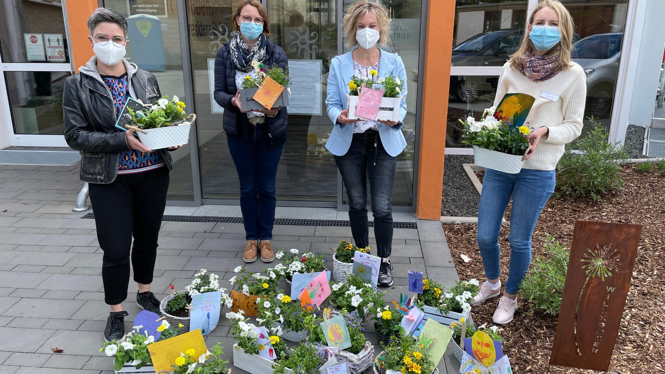 Melanie Teixeira, Brunhilde Steinmetz, Katja Neisius-Umbscheiden (Remise) und Frederike Hassel, Sozialdienstleiterin Seniorenresidenz Sankt Peter, freuen sich über die Blumengrüße der Ehranger Familien für die Senioren.