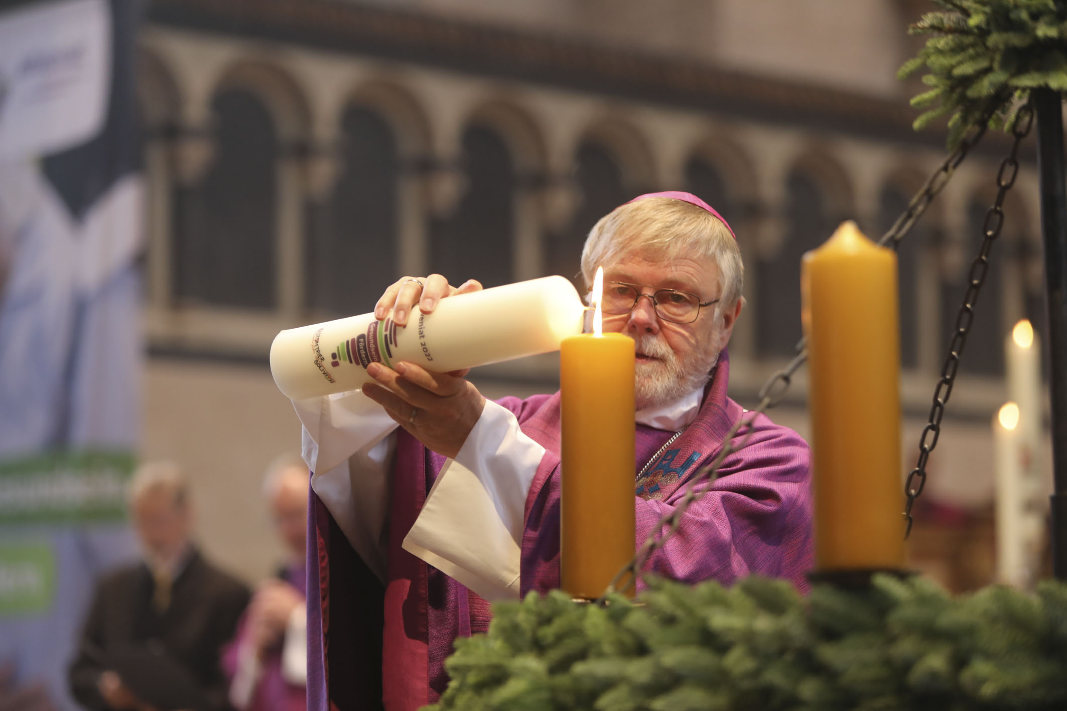 Bischof Eugenio Coter zündet die Aktionskerze am Adventskranz an.