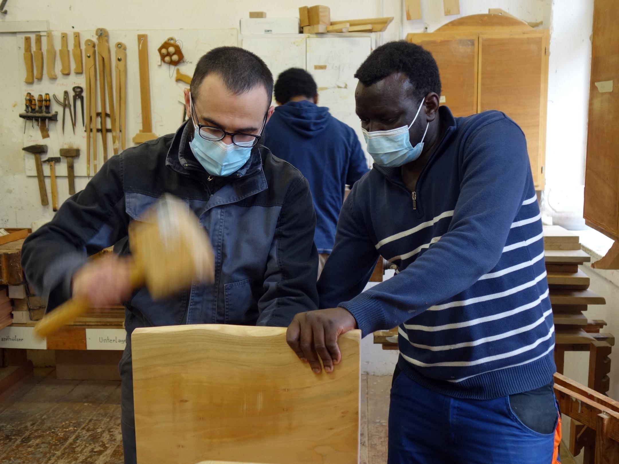 Maaz Dadajev (links) und Musa Istiak arbeiten an einem Bänkchen.