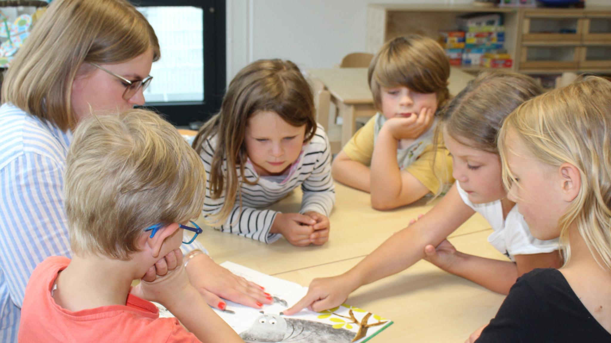 Die Vorschulkinder der katholischen Kita St. Pius besprechen gemeinsam ein Buch. Foto: Katholische KiTa gGmbH Koblenz/Cara Küpper