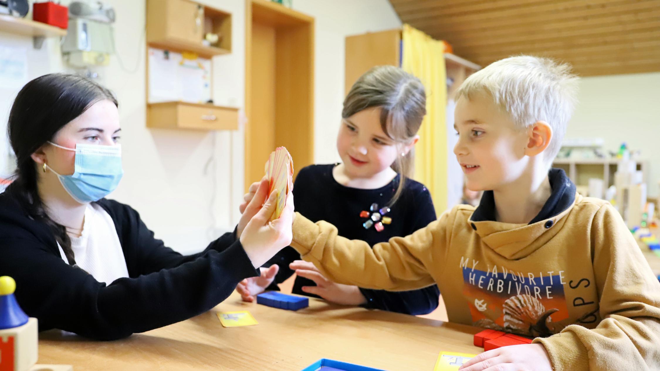 Mats und Ida spielen mit Erzierhin Jana Thömmes. in jedem Raum wird auf den Tischen ein Spiel angeboten, das die Kinder nutzen können - ebenso ist es mit Büchern, die immer zur Themenwelt des Raums passen.